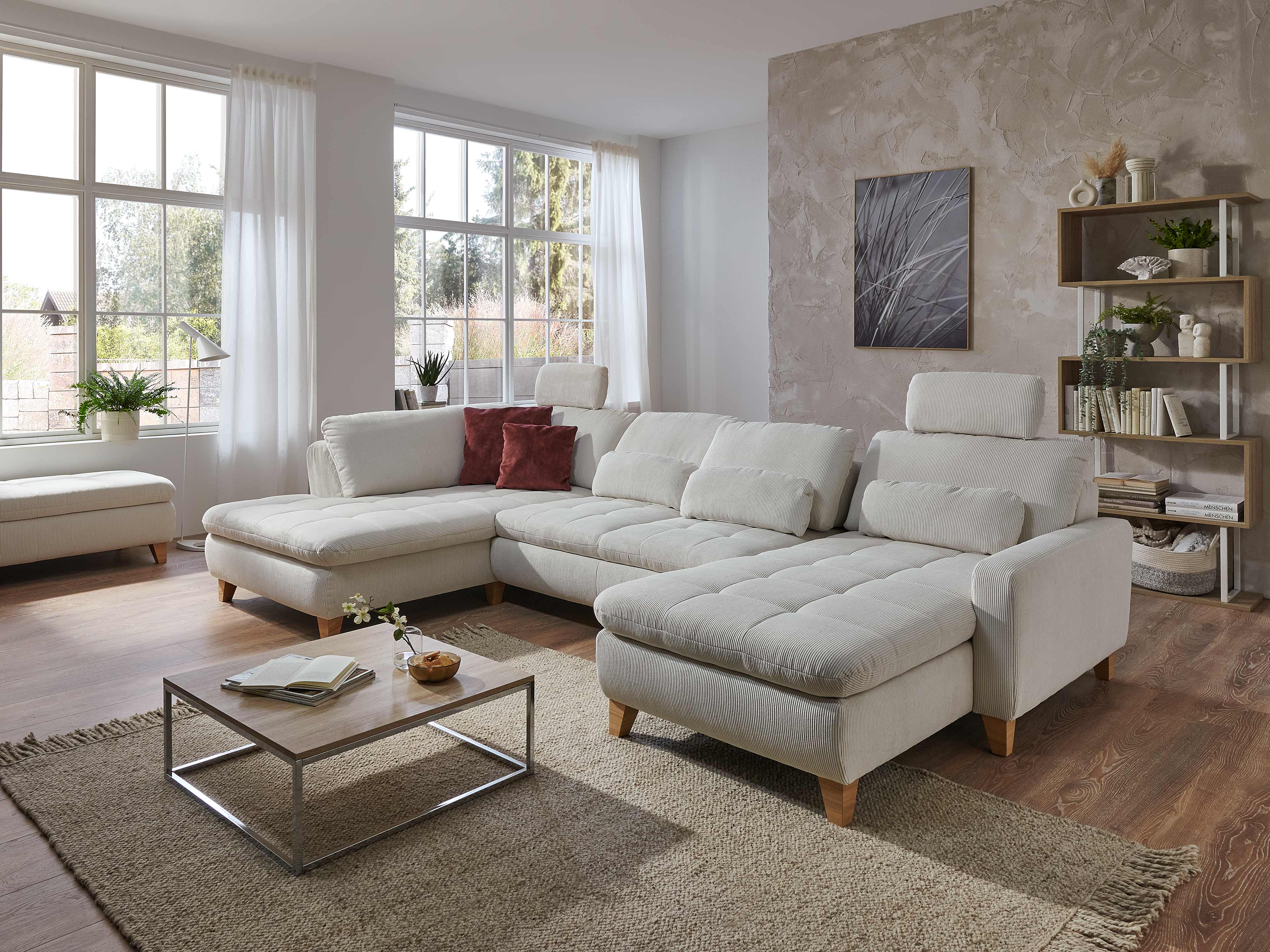Ecksofa in L-Form mit cremefarbenem Stoffbezug, gepolsterten Sitzflächen und Holzfüßen