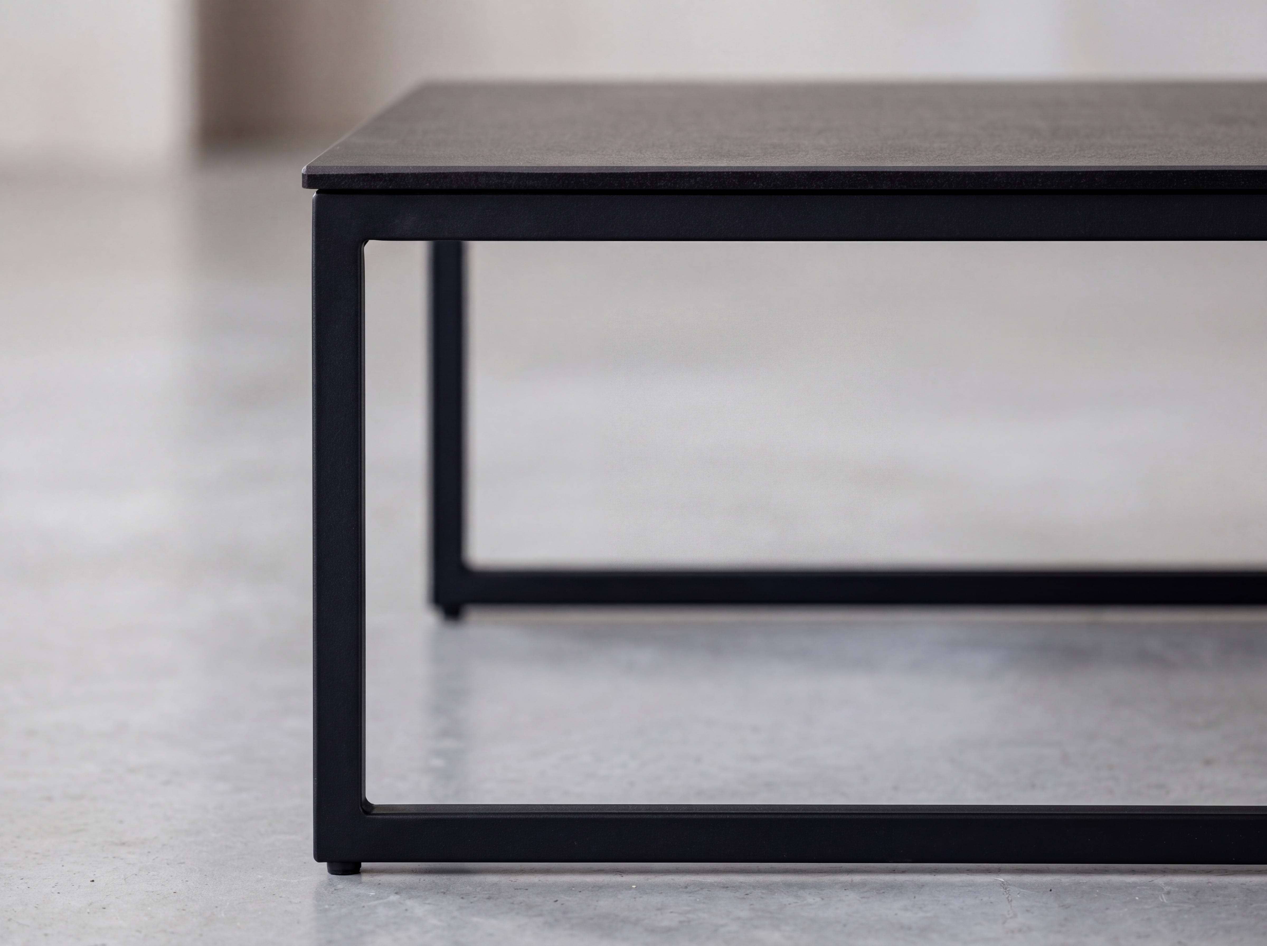 Rechteckiger Couchtisch mit schwarzer Tischplatte und Gestell aus Metall in kantigem Design