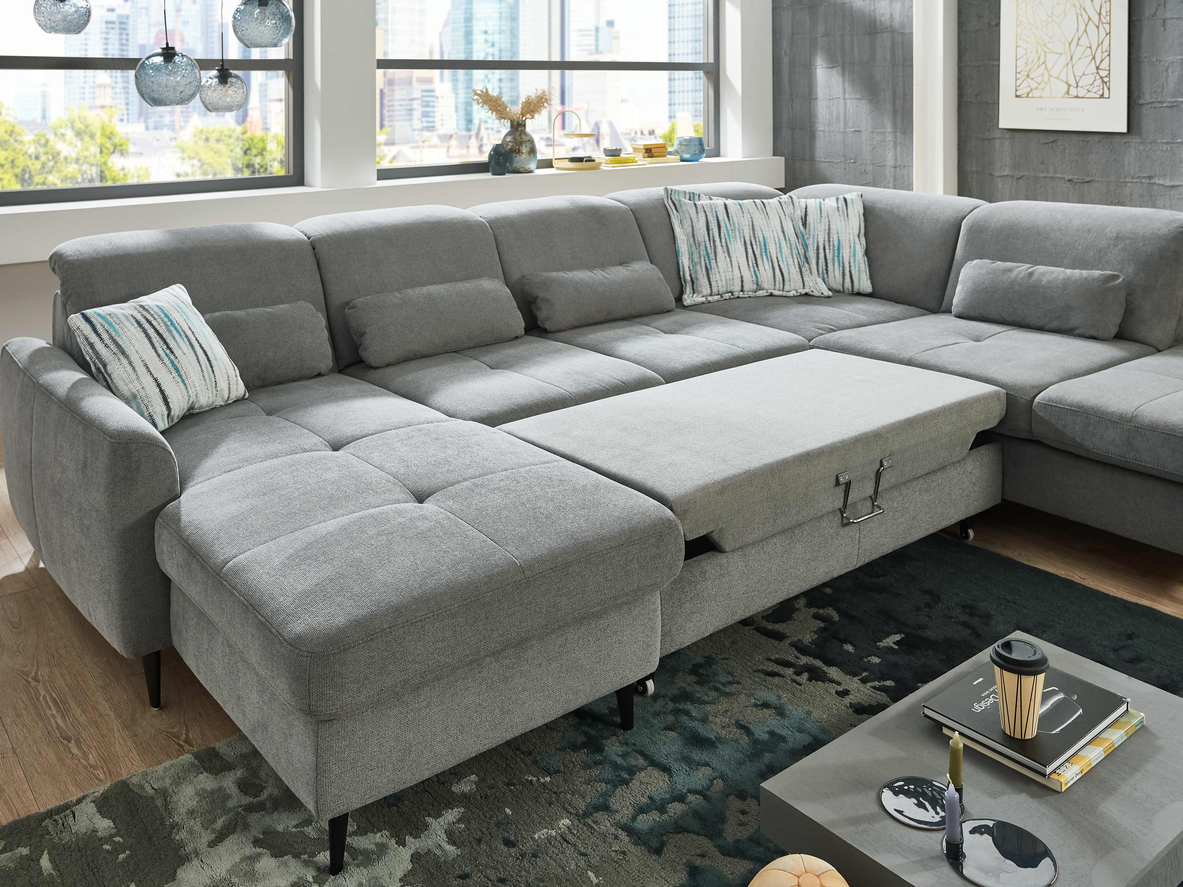 Ecksofa Como in U-Form aus grauem Stoff mit Armlehnen, gepolsterter Rückenlehne und Schlaffunktion