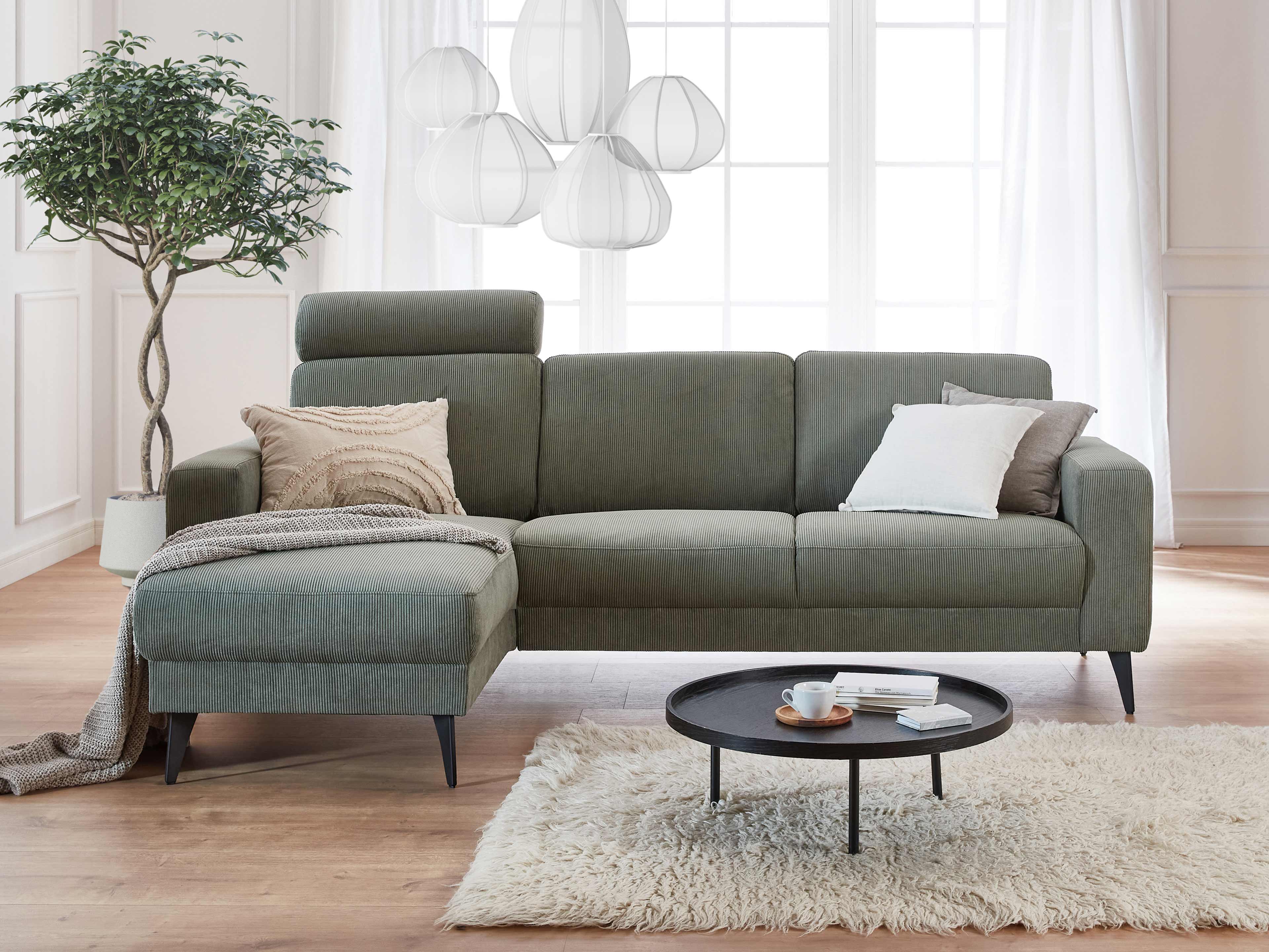 Ecksofa Kabs Polsterwelt, Bezug aus grünem Stoff, L-Form, Armlehnen, schwarze Füße, Kopfstütze