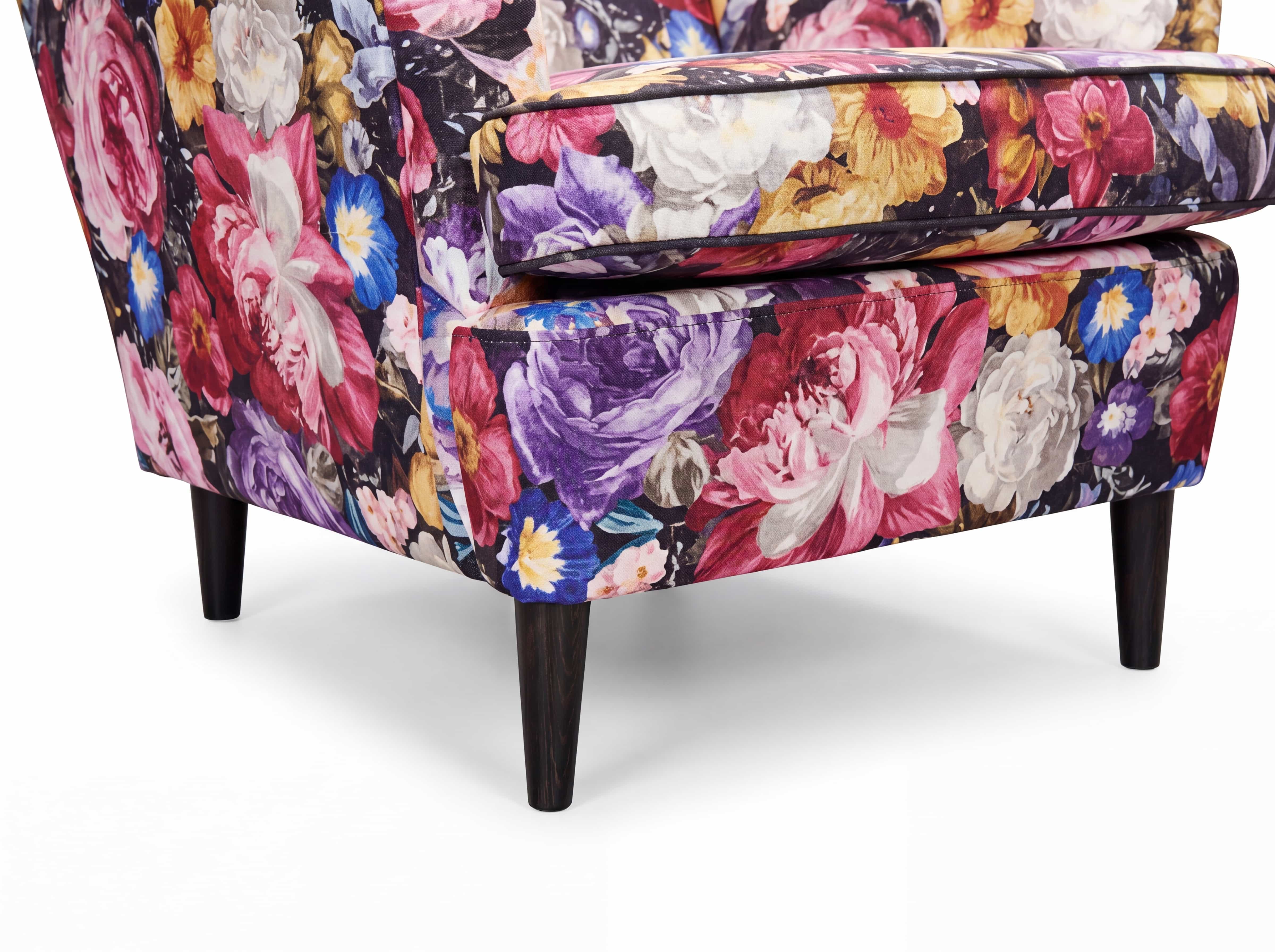 Sessel mit floral gemustertem Stoffbezug in bunten Farben und konischen dunklen Holzbeinen