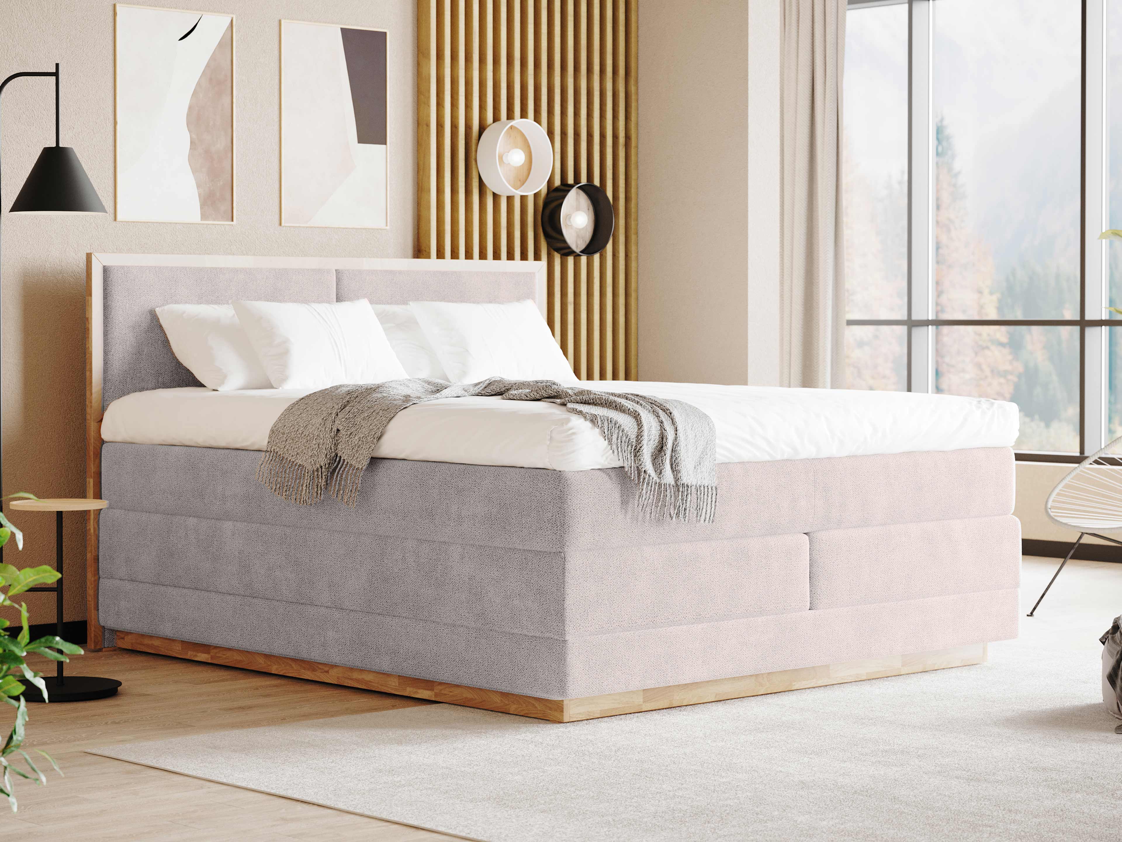 Boxspringbett mit hohem, gepolstertem Kopfteil und Stoffbezug in hellem Grau auf Holzsockel