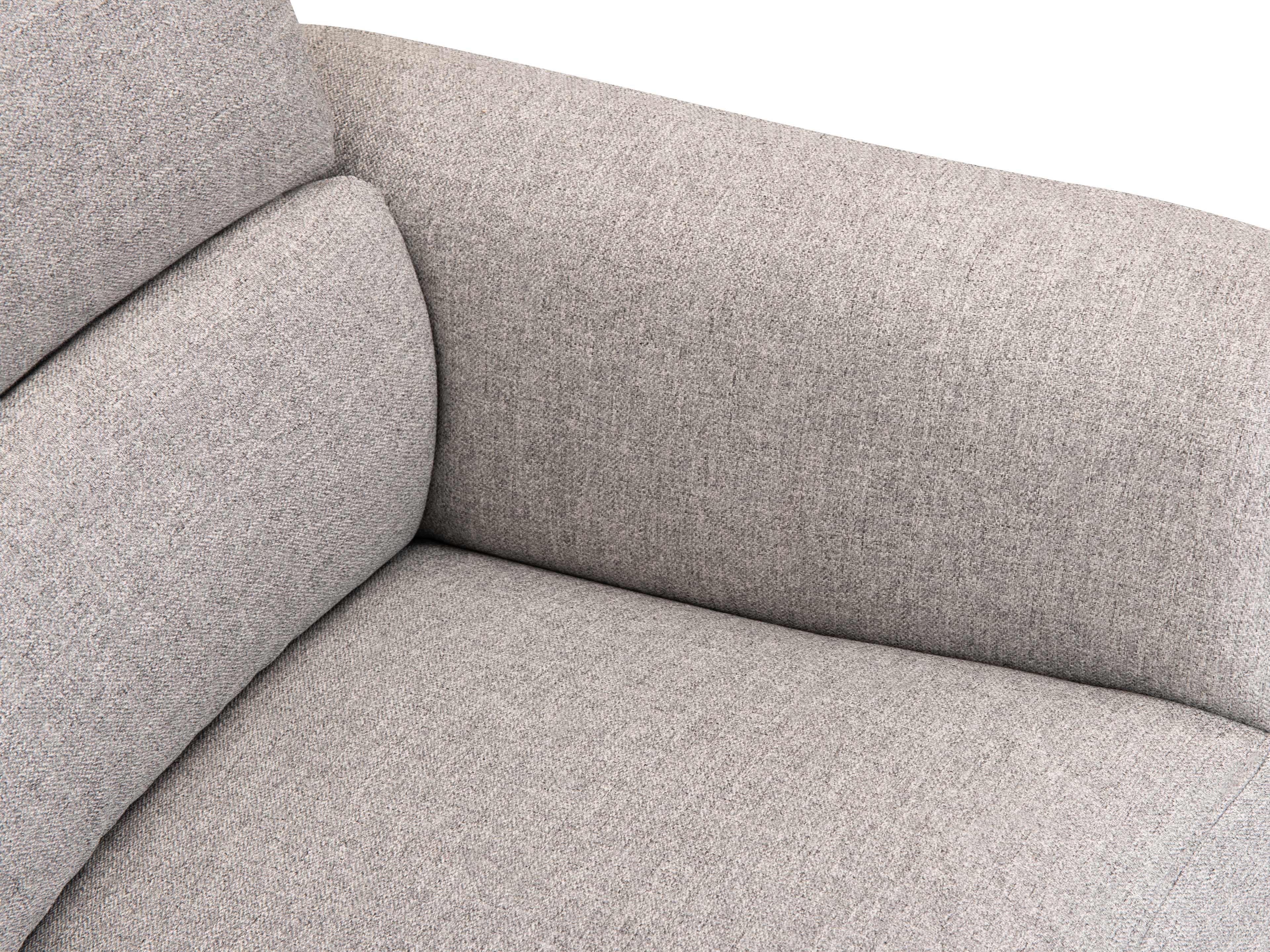 Detailaufnahme Armlehne und Sitzfläche eines grauen Stoffsofas mit strukturierter Polsterung