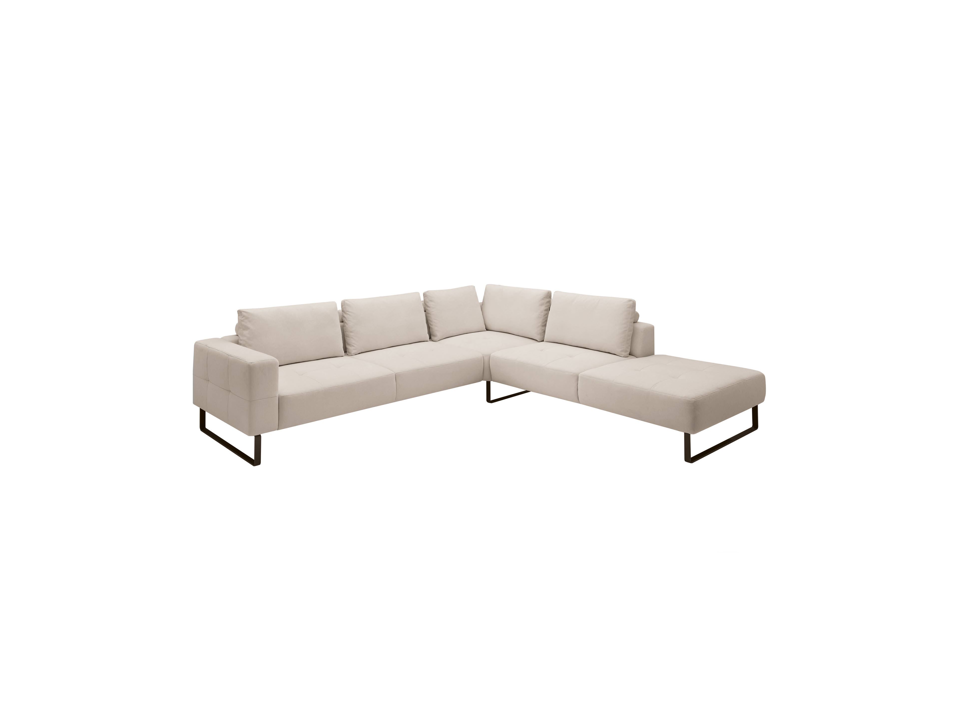 Ecksofa mit hellem Stoffbezug, vier Rückenkissen, gepolsterten Sitzflächen und Metallkufenfüßen