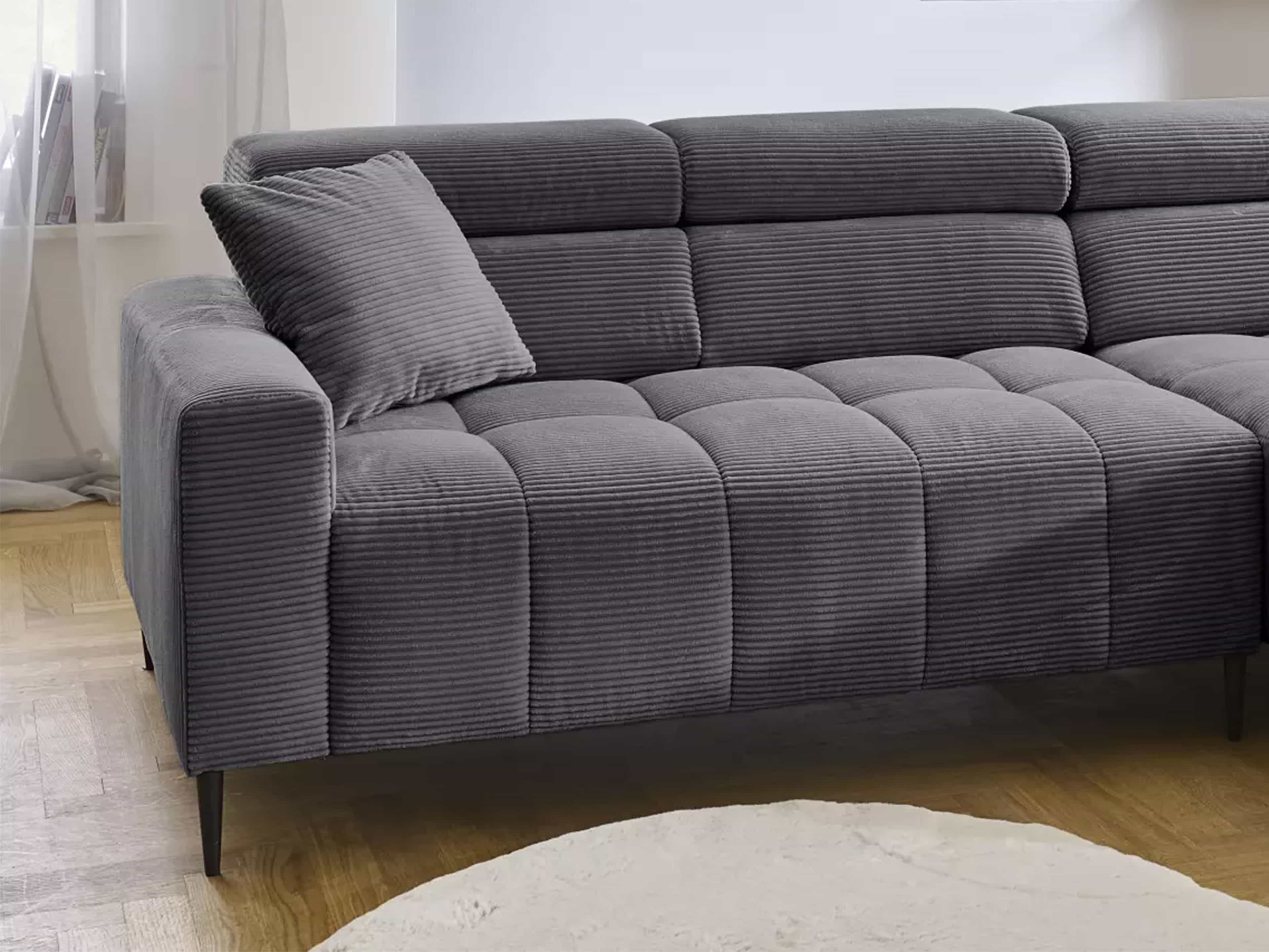 Ecksofa mit grauem Cordbezug, breiten Armlehnen, gepolsterter Sitzfläche und schwarzen Füßen