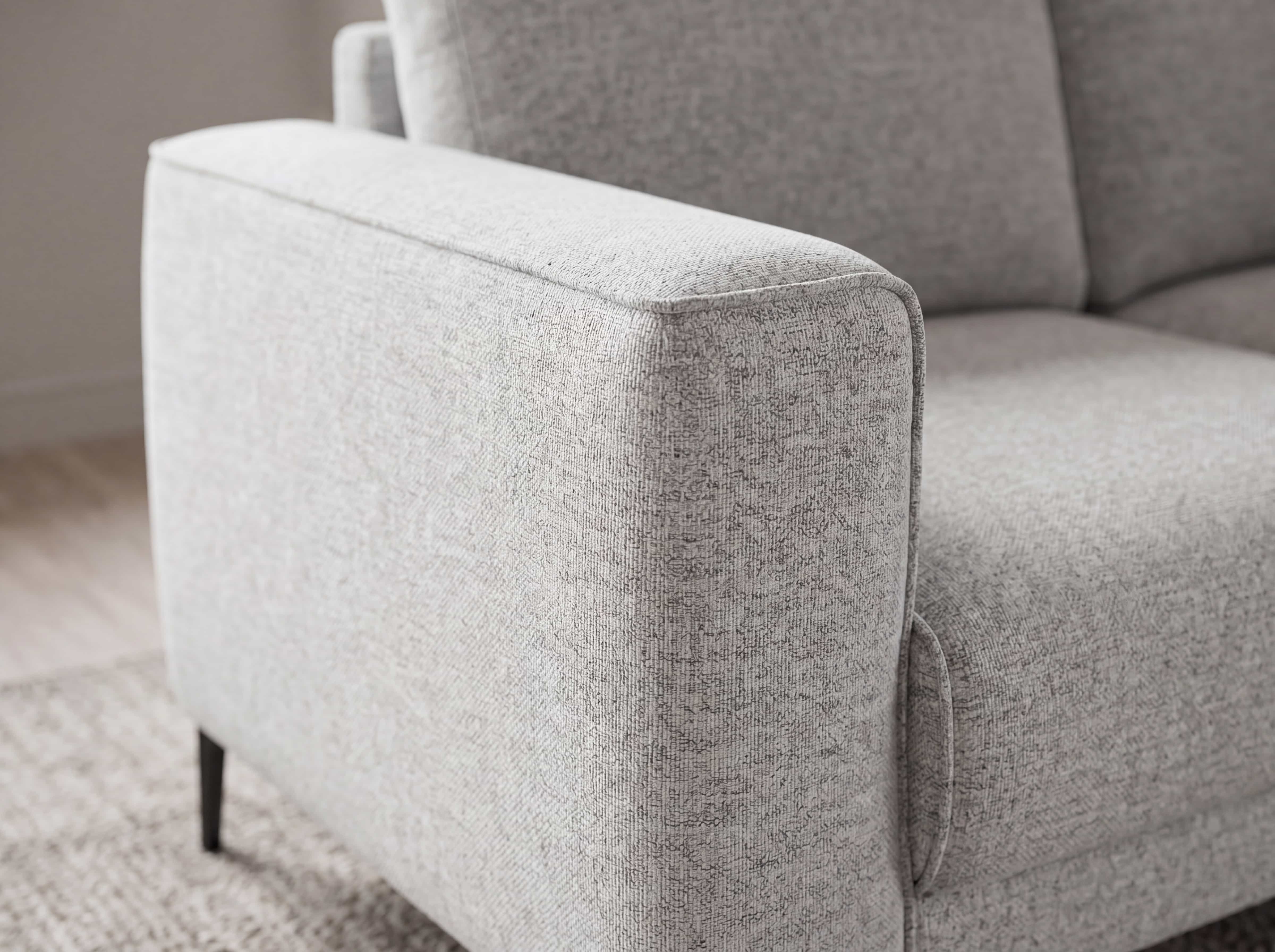 Ecksofa mit hellgrauem Stoffbezug, gerader Armlehne und schwarzen, schmalen Metallfüßen