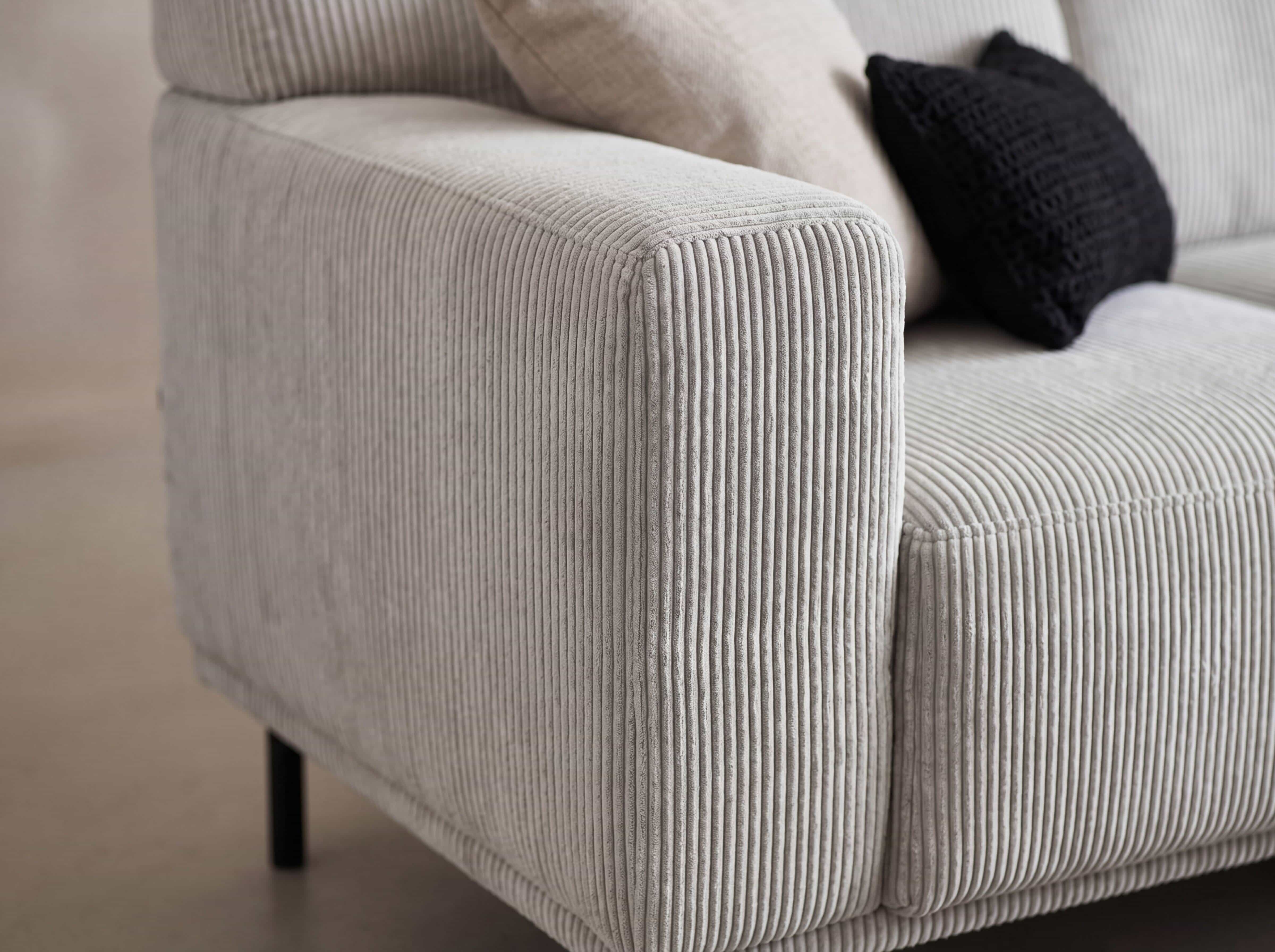 Ecksofa Malcuken – Detailansicht mit beigem Cordbezug, breiter Armlehne und sichtbaren Ziernähten