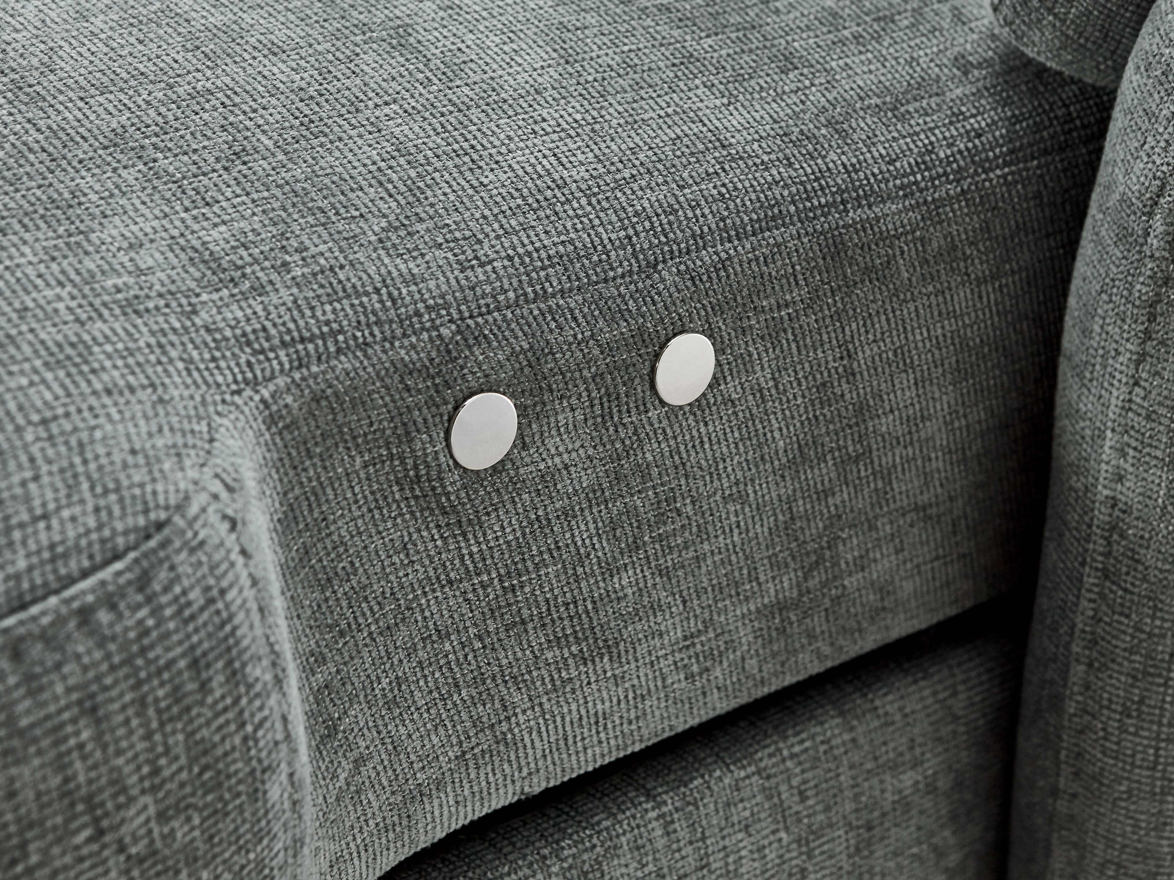 Detailansicht eines grauen Stoffsofas mit strukturierter Oberfläche und zwei runden Metallknöpfen.