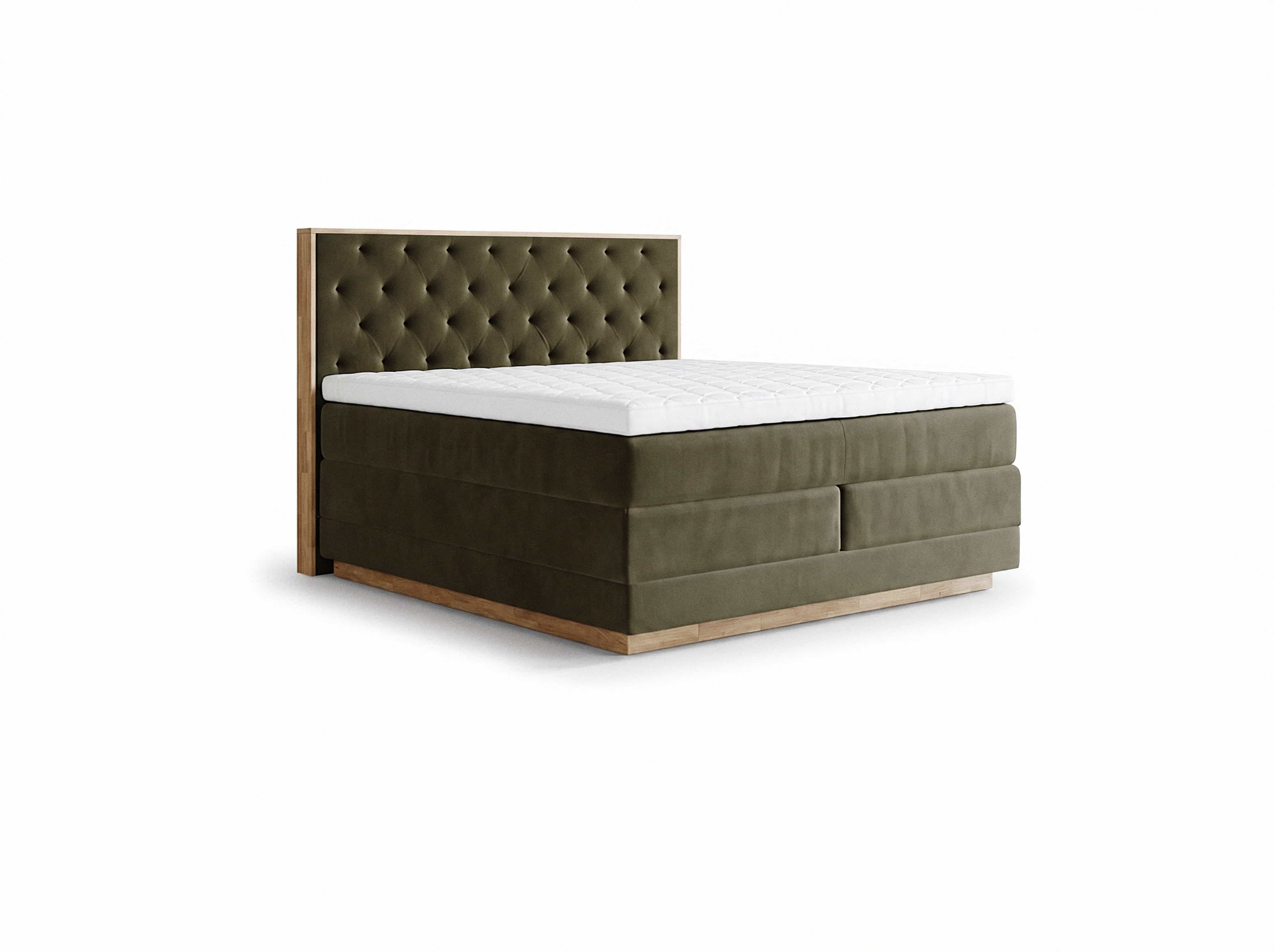 Boxspringbett mit olivgrünem Stoffbezug, gesteppter weißer Matratze und kopfhohem Polsterkopfteil