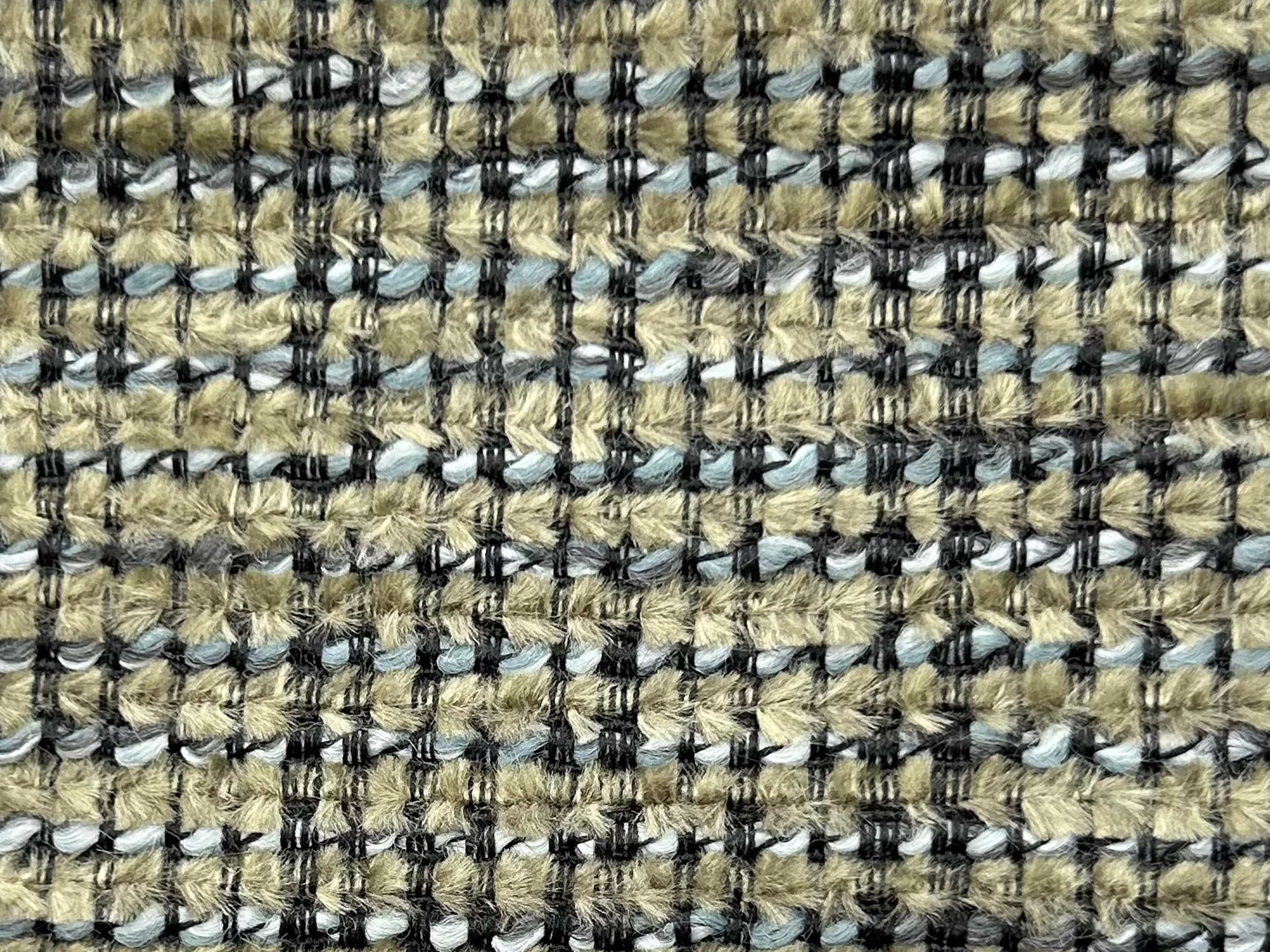 Nahaufnahme eines strukturierten Polsterstoffs in Beige mit schwarzen und blauen Fäden in Karomuster.