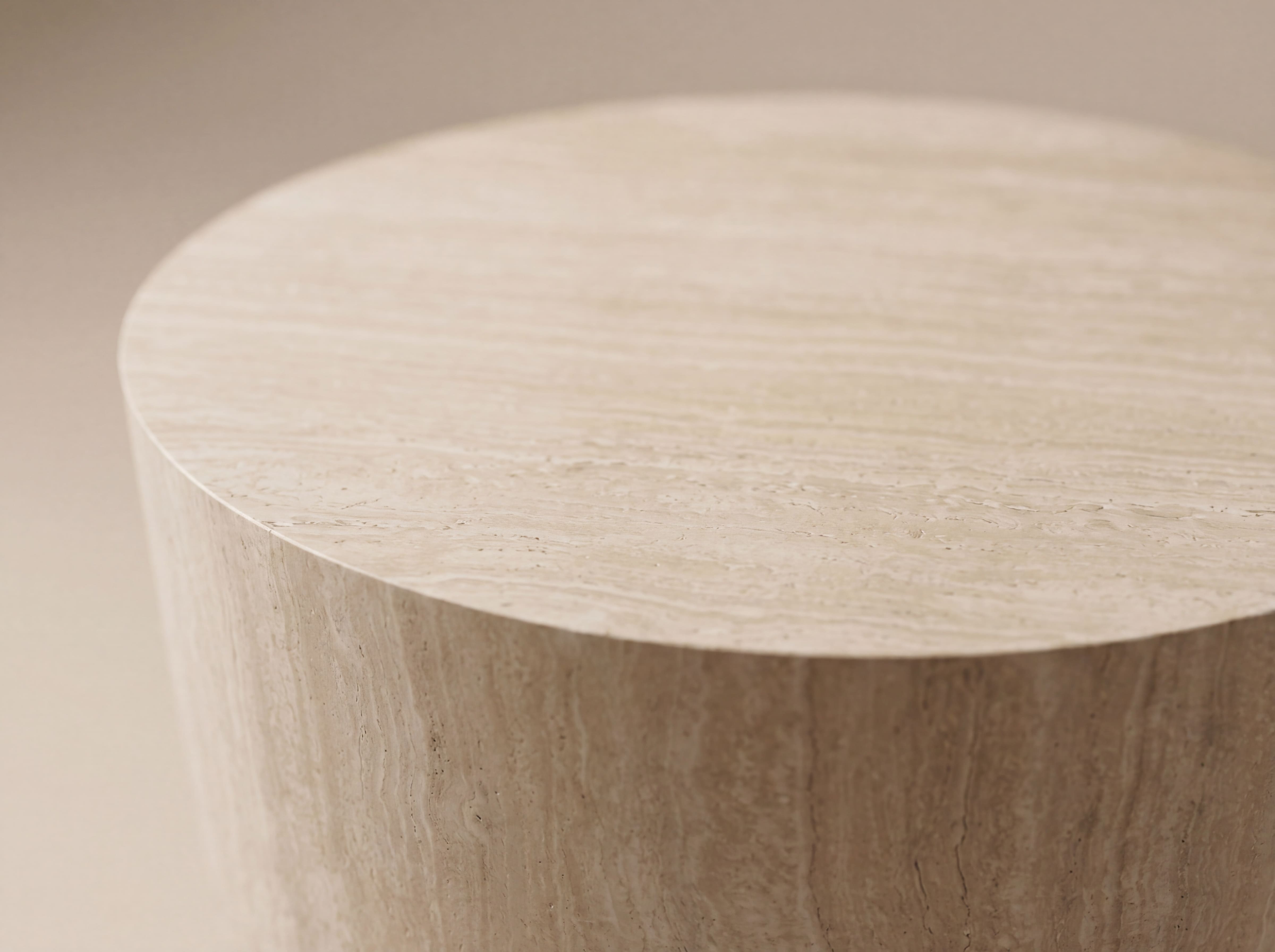 Runder Couchtisch mit glatter, heller Travertin-Oberfläche und markanter Natursteinstruktur