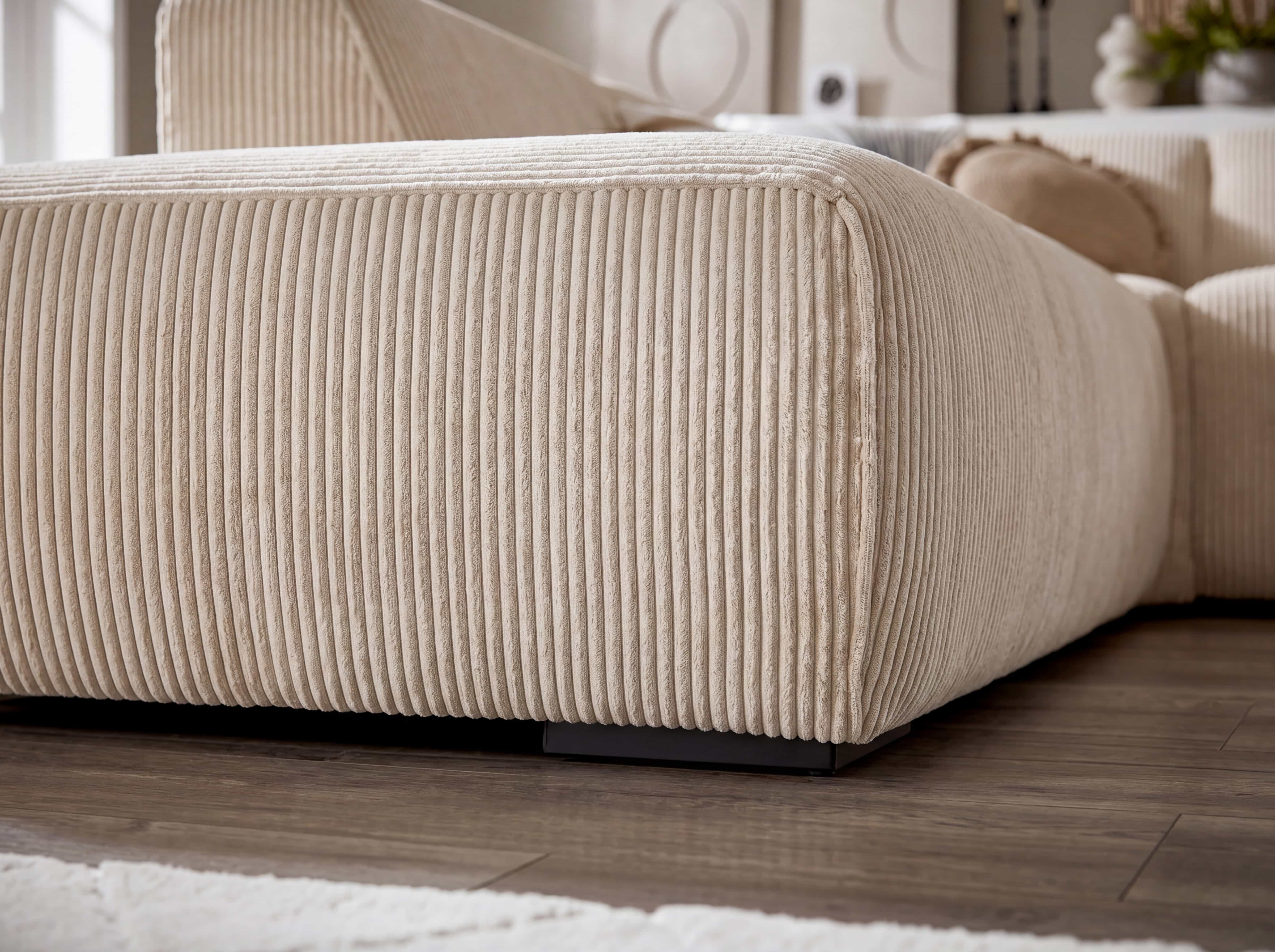 Ecksofa Lando mit beigem Cordbezug, breiter Korpus, feine Längsrillen, niedrige schwarze Füße
