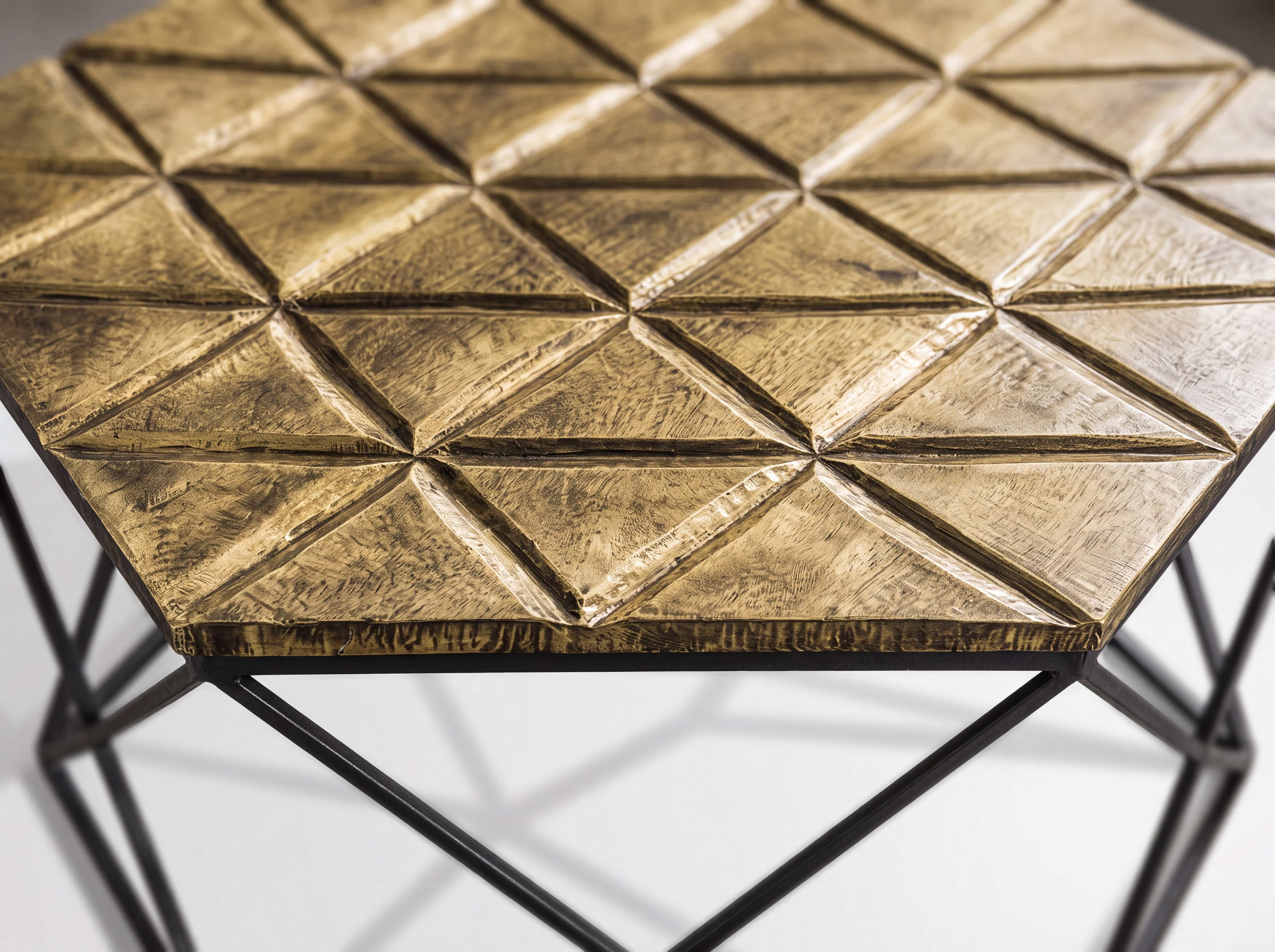 Couchtisch mit sechseckiger, goldfarbener Metallplatte in geometrischer Struktur und schwarzem Metallgestell