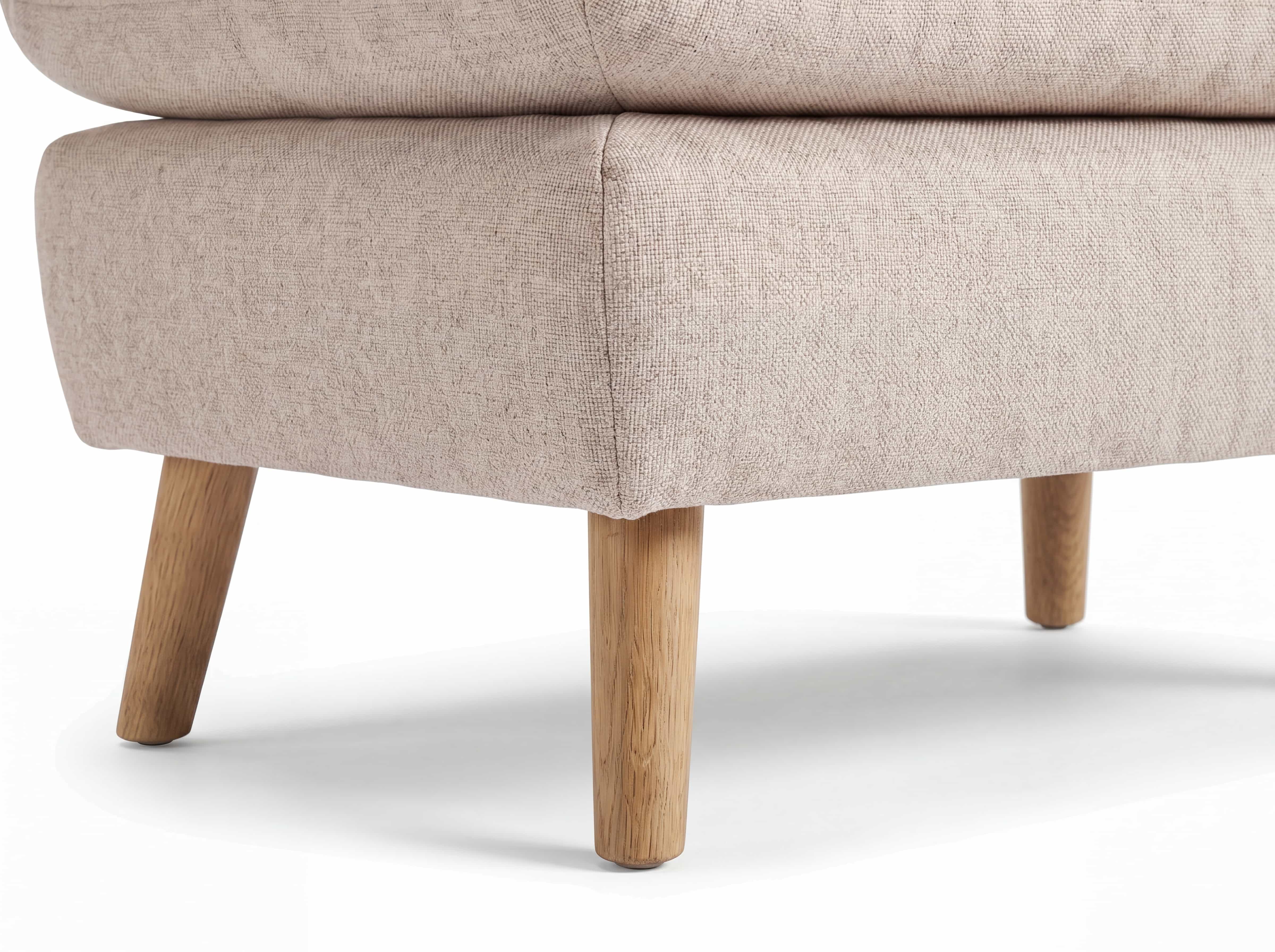 Sofa mit beigem Stoffbezug und runder Polsterung, schräg gestellte Holzfüße, Detailansicht Ecke