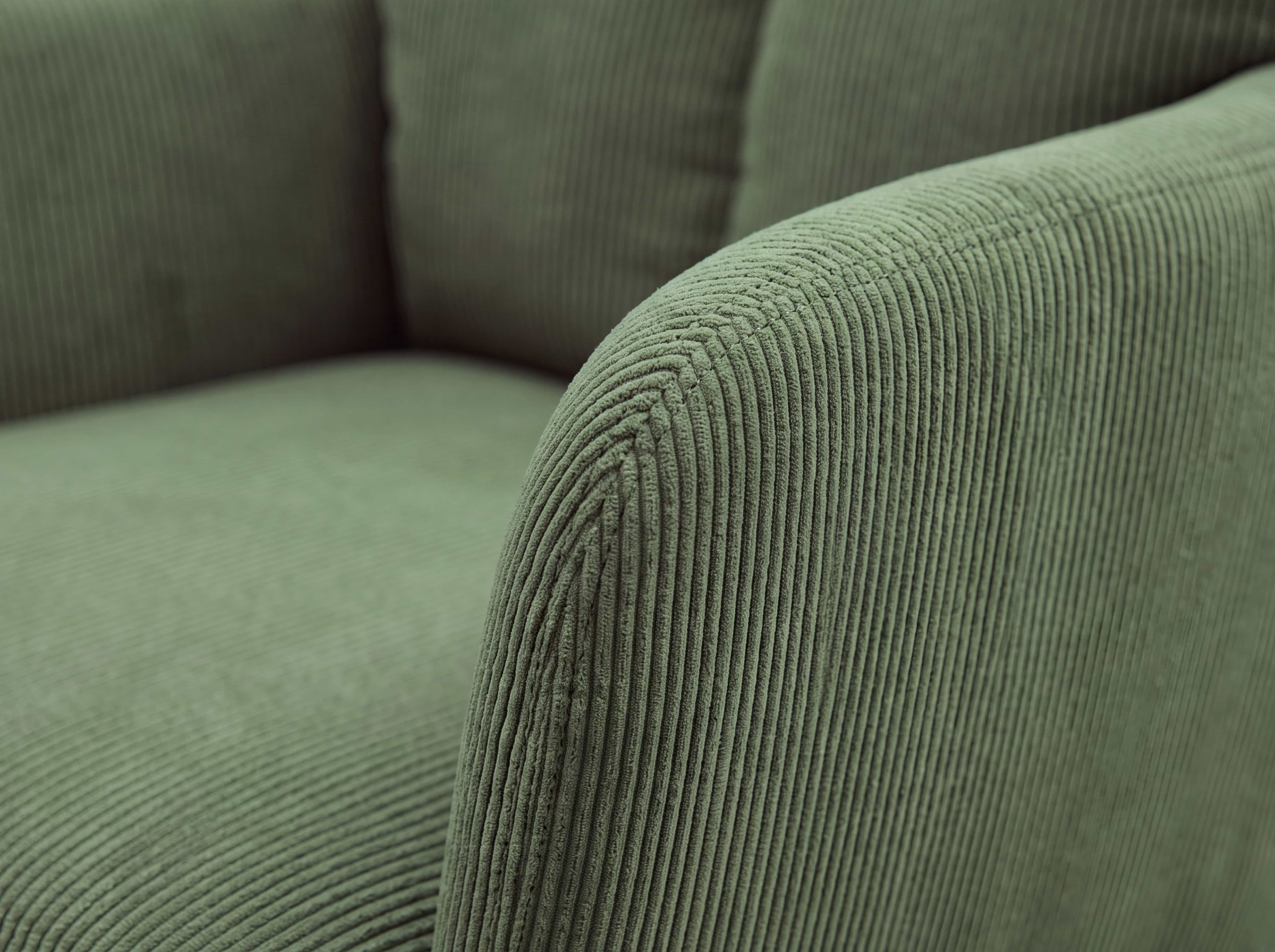 Sessel Cord Grün mit abgerundeter Armlehne und sichtbarer Rippenstruktur im Detail