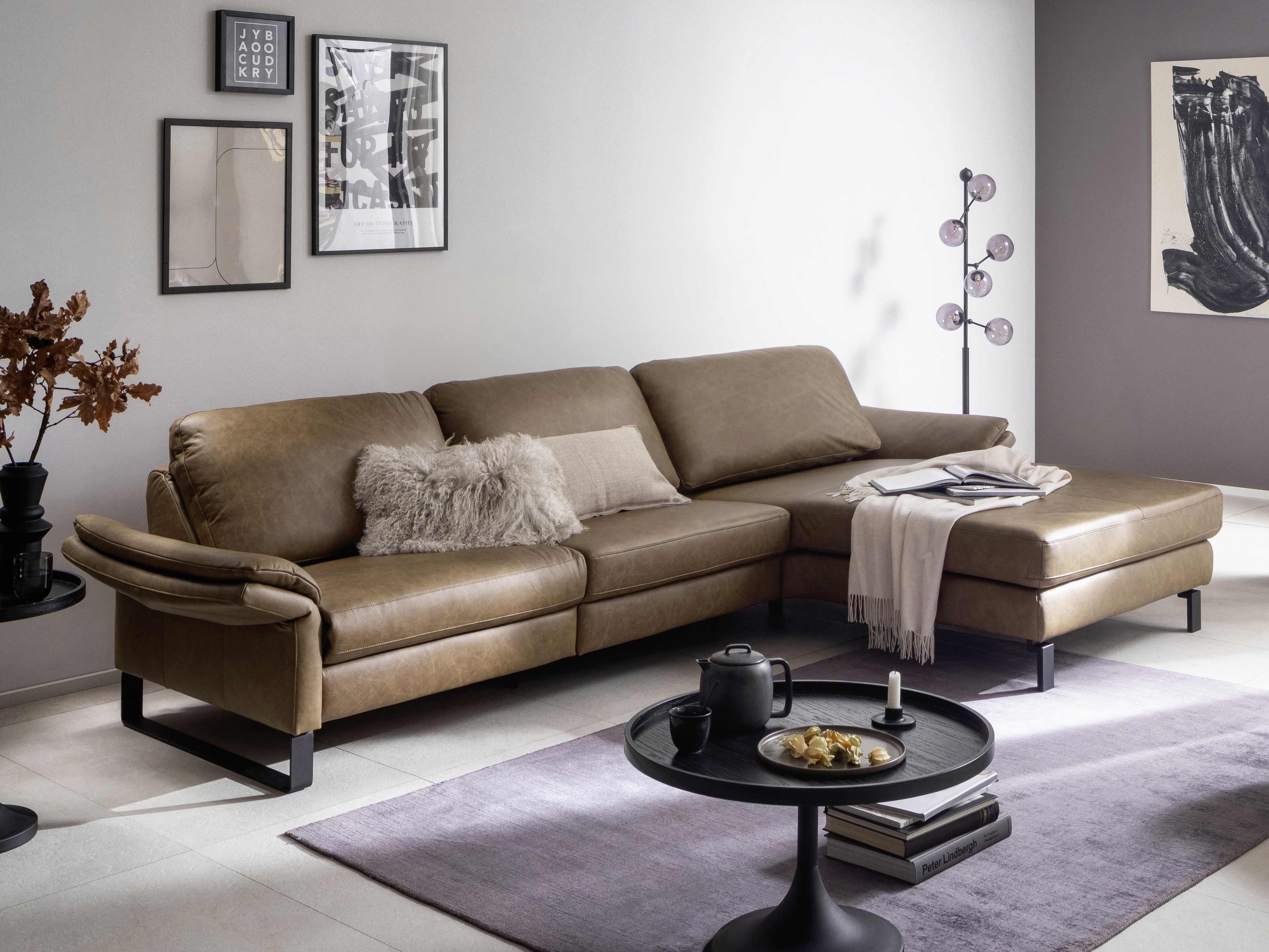Ecksofa Livorno aus braunem Leder mit breiten Armlehnen, gepolsterter Sitzfläche und schwarzen Metallfüßen
