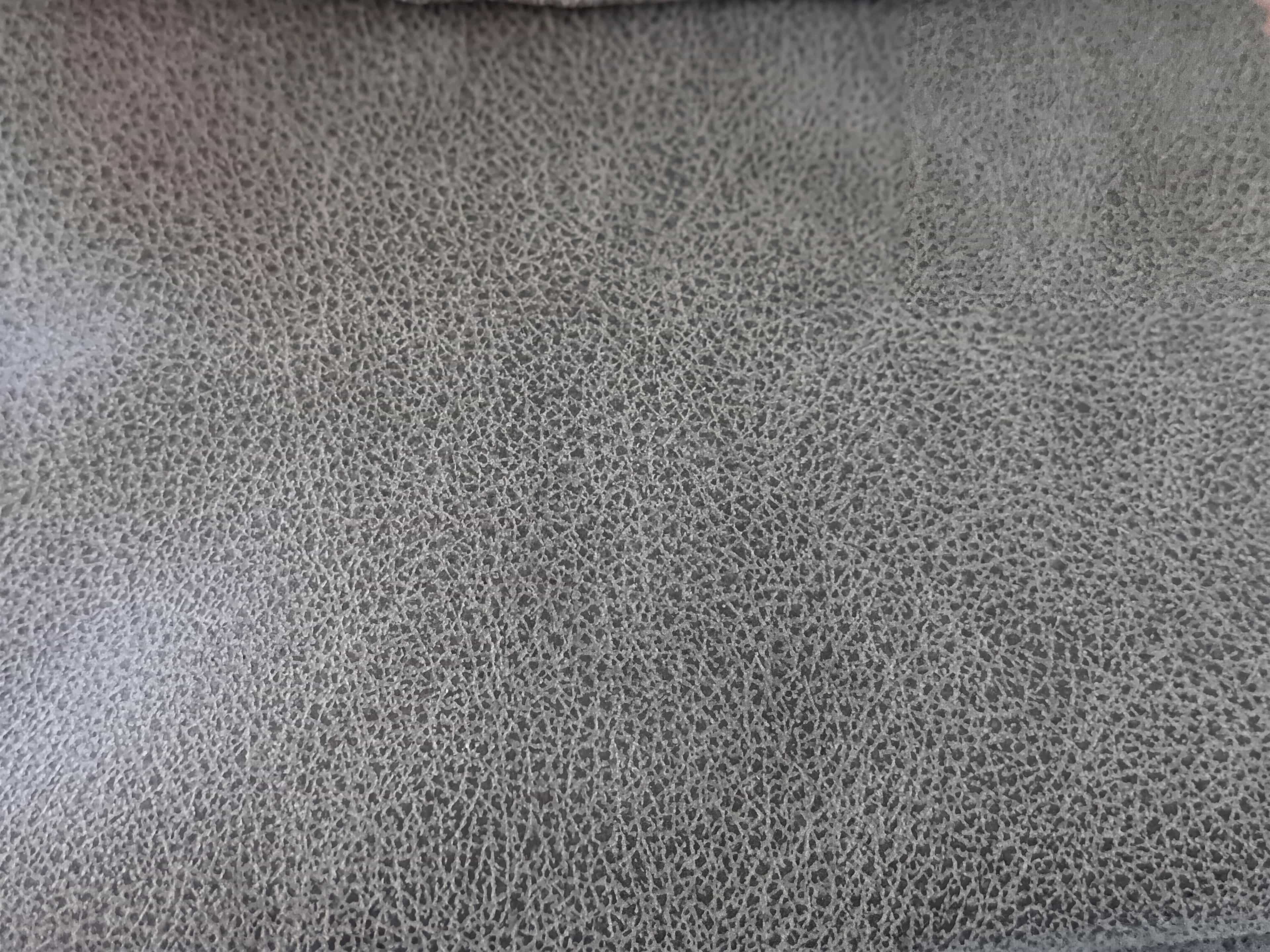 Graues Polster mit feiner Lederstruktur, Nahaufnahme der Oberfläche eines Sofas