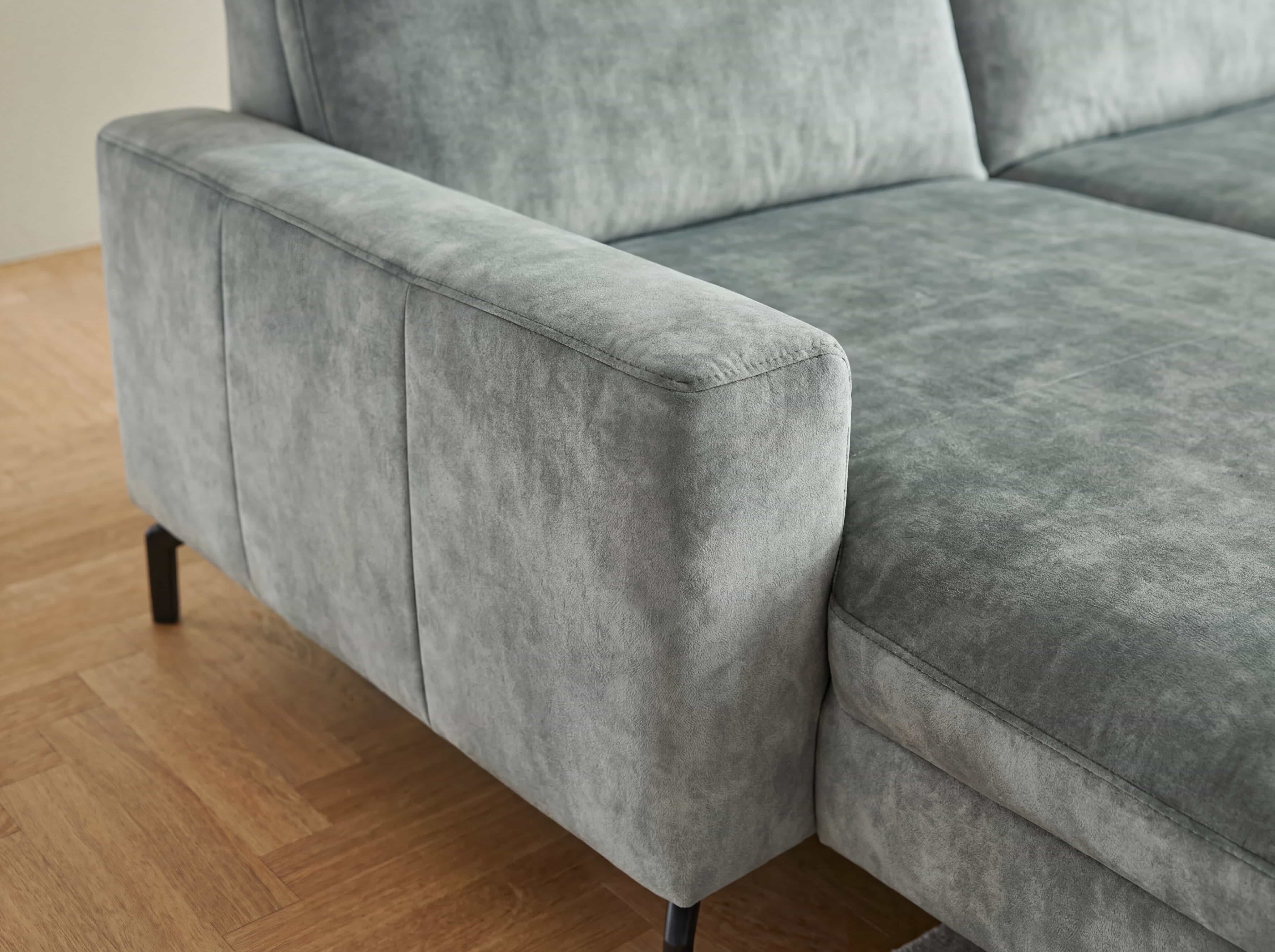 Ecksofa mit grauem Stoffbezug, breiter Armlehne und schwarzen Füßen, gepolsterte Sitzfläche
