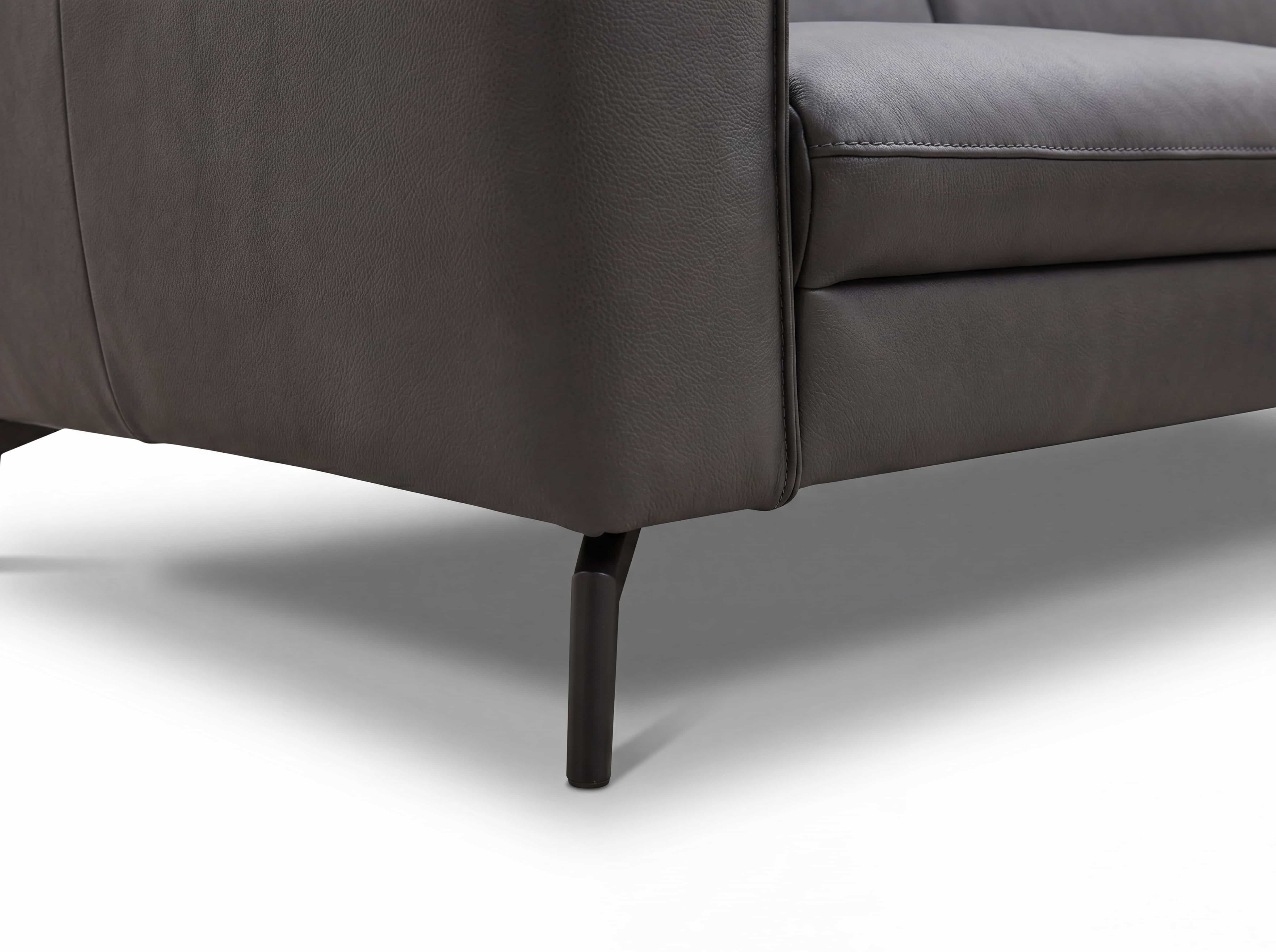 Ecksofa Kabs Polsterwelt mit dunklem Lederbezug und schwarzen, schmalen Metallfüßen im Detail