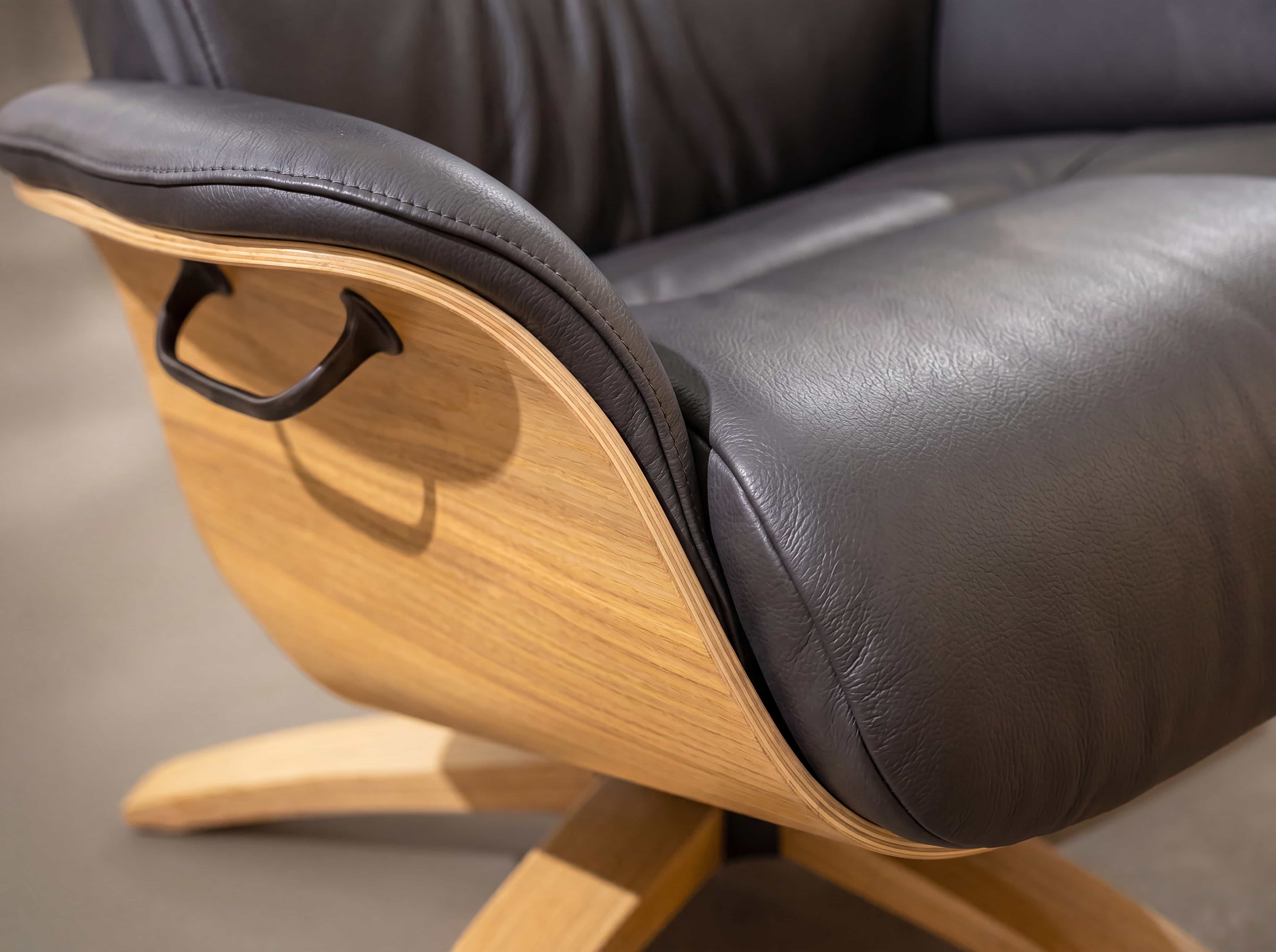 Relaxsessel Kareike – Detailansicht mit dunkelgrauem Bezug, Holzseitenteil und Metallgriff