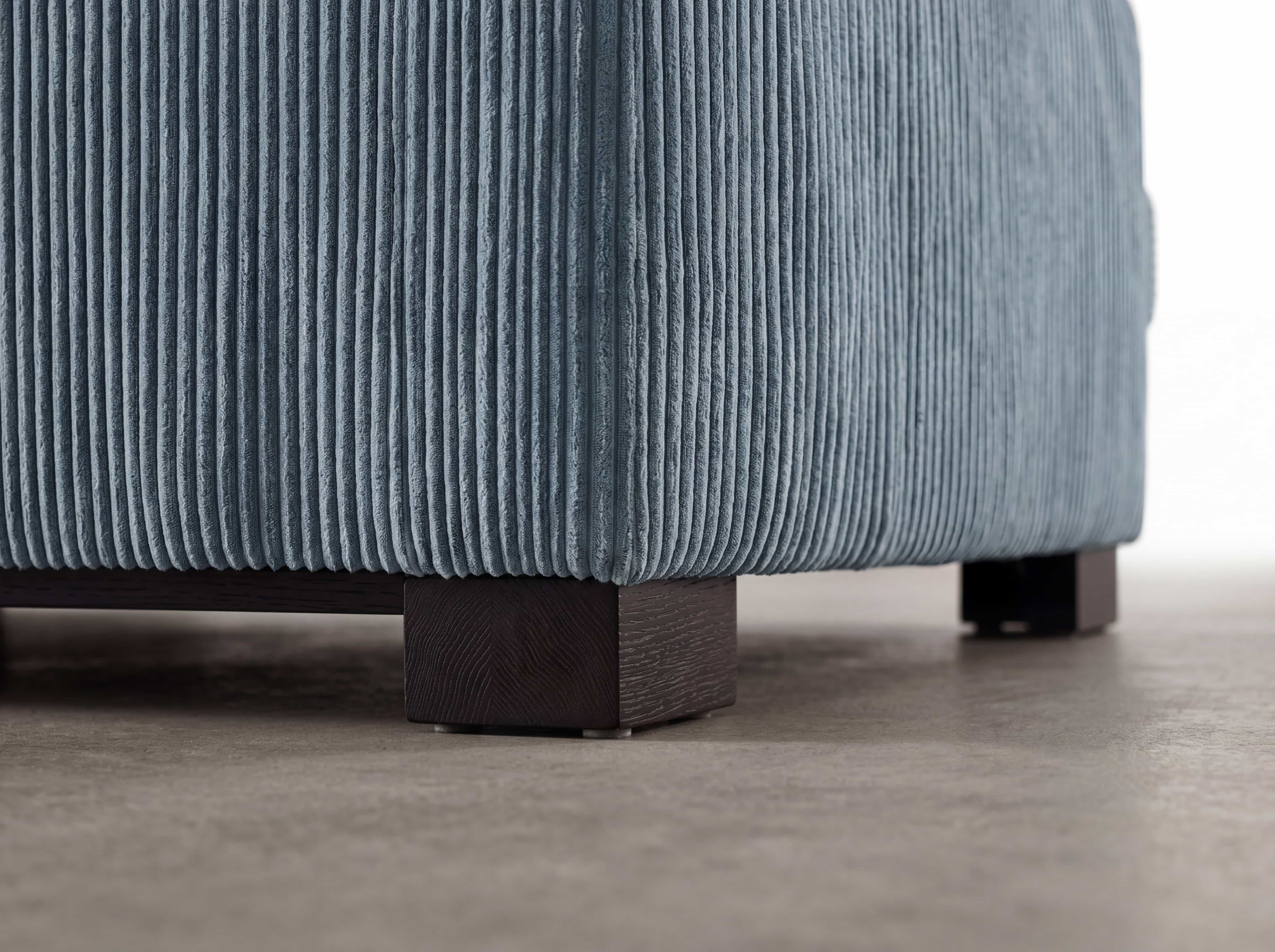 Ecksofa Cordula mit blauer Cord-Oberfläche und dunkelbraunen eckigen Holzfüßen im Detail