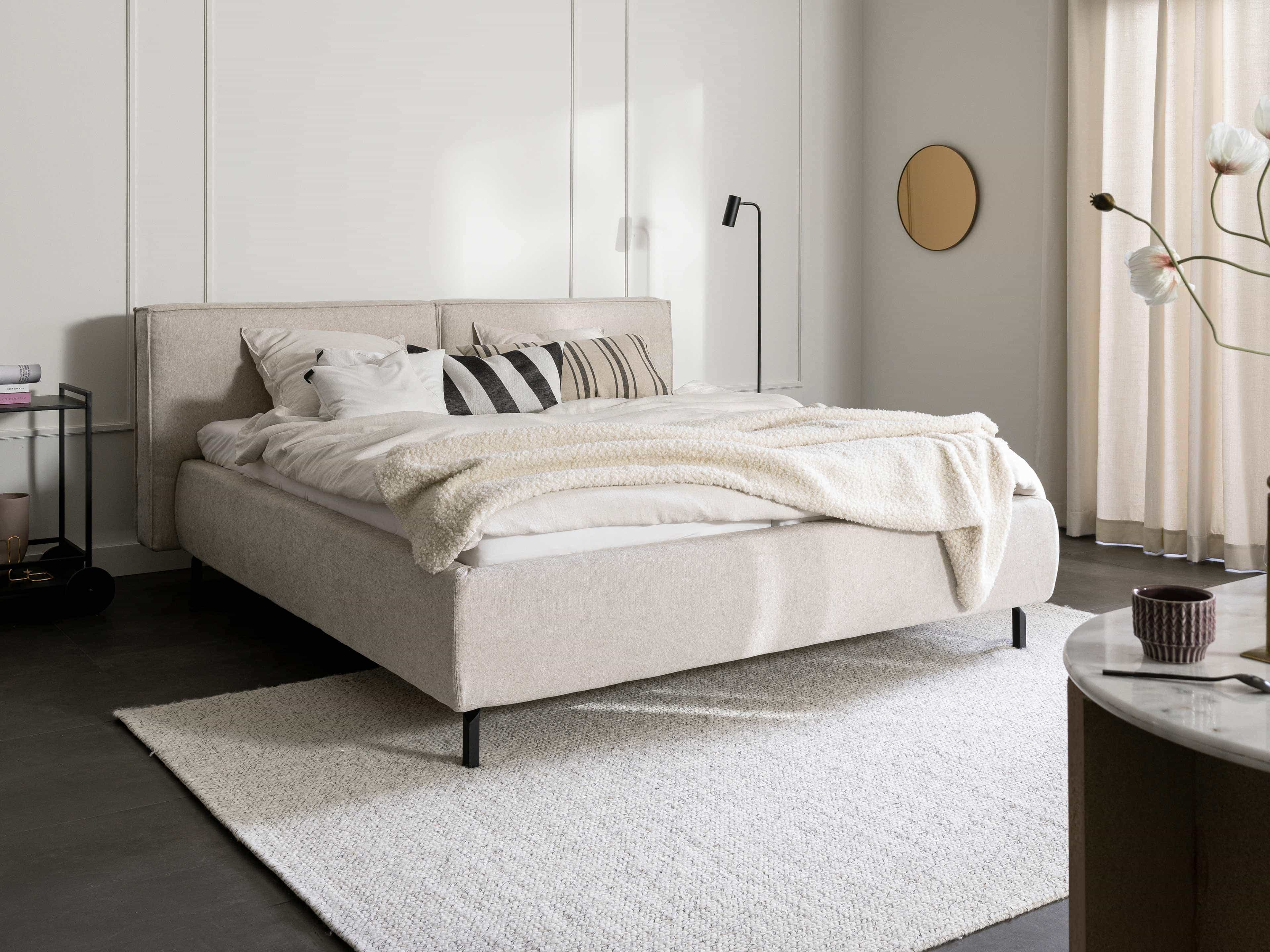 Polsterbett mit Stoffbezug in Beige, gepolstertem Kopfteil und schwarzen Metallfüßen