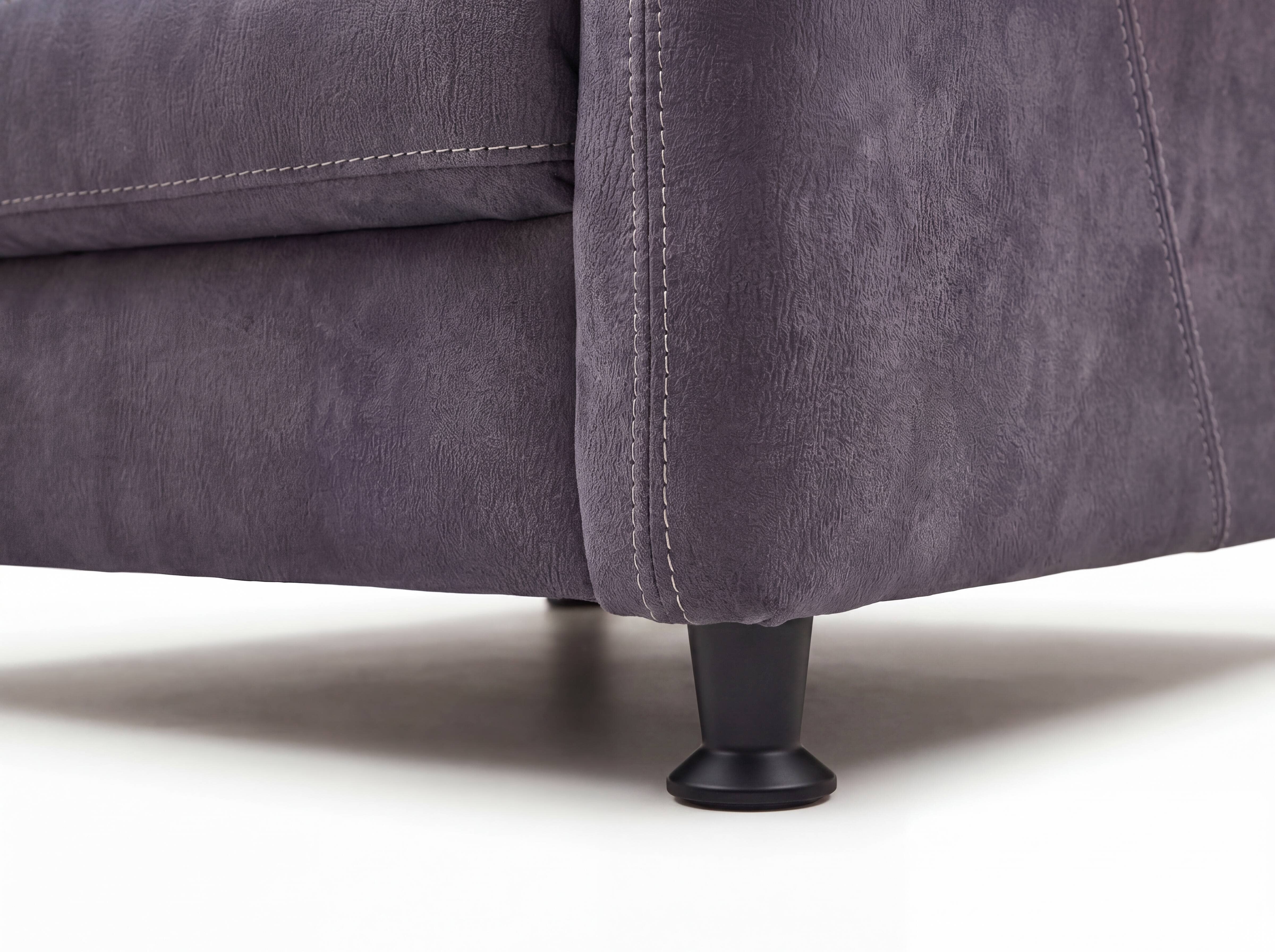 Sofa mit grauem Stoffbezug, deutlicher Ziernaht und rundem schwarzen Fuß aus Kunststoff