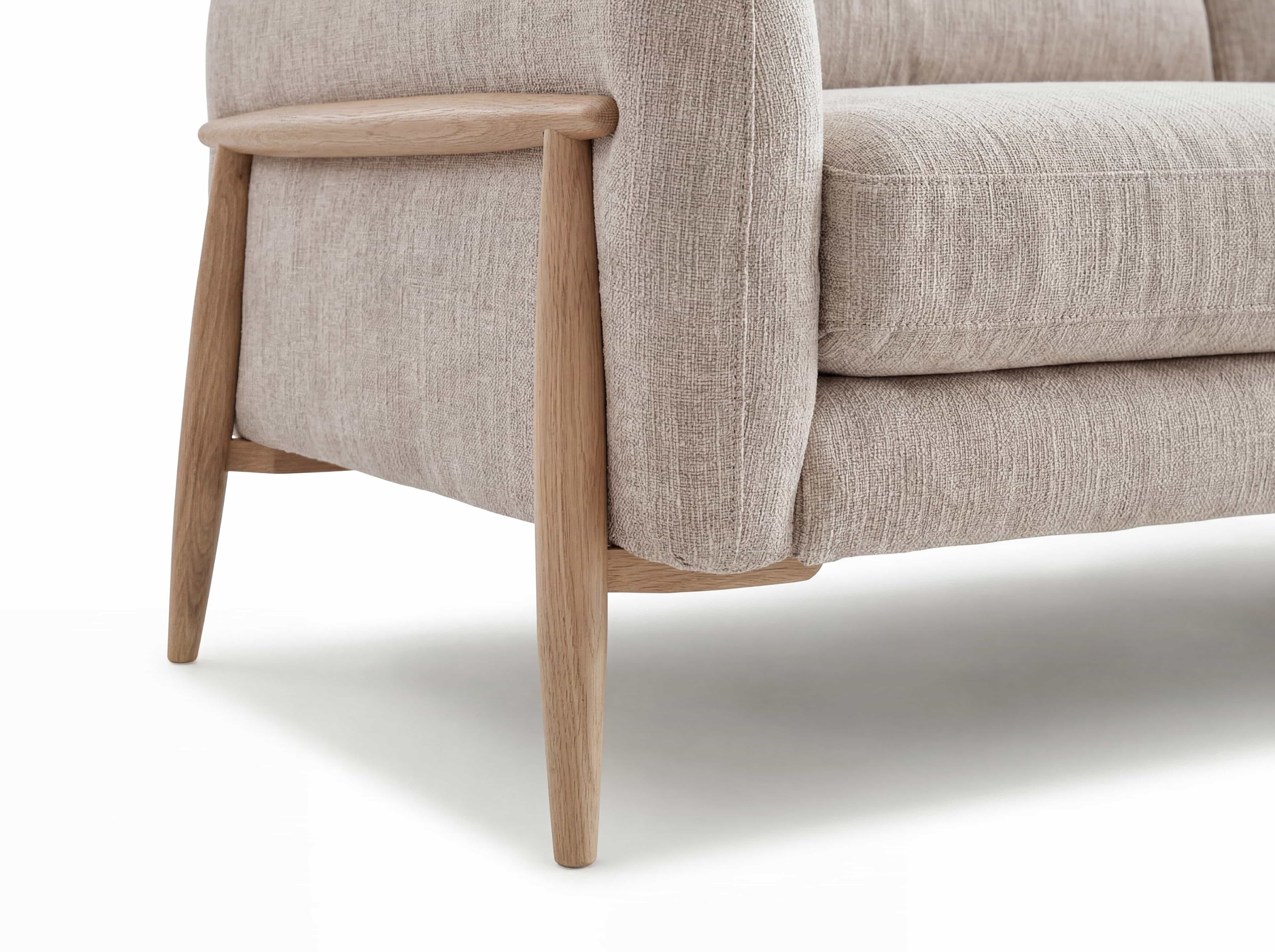 Ecksofa mit beige gepolstertem Stoffbezug, abgerundeten Armlehnen und schrägen Holzfüßen