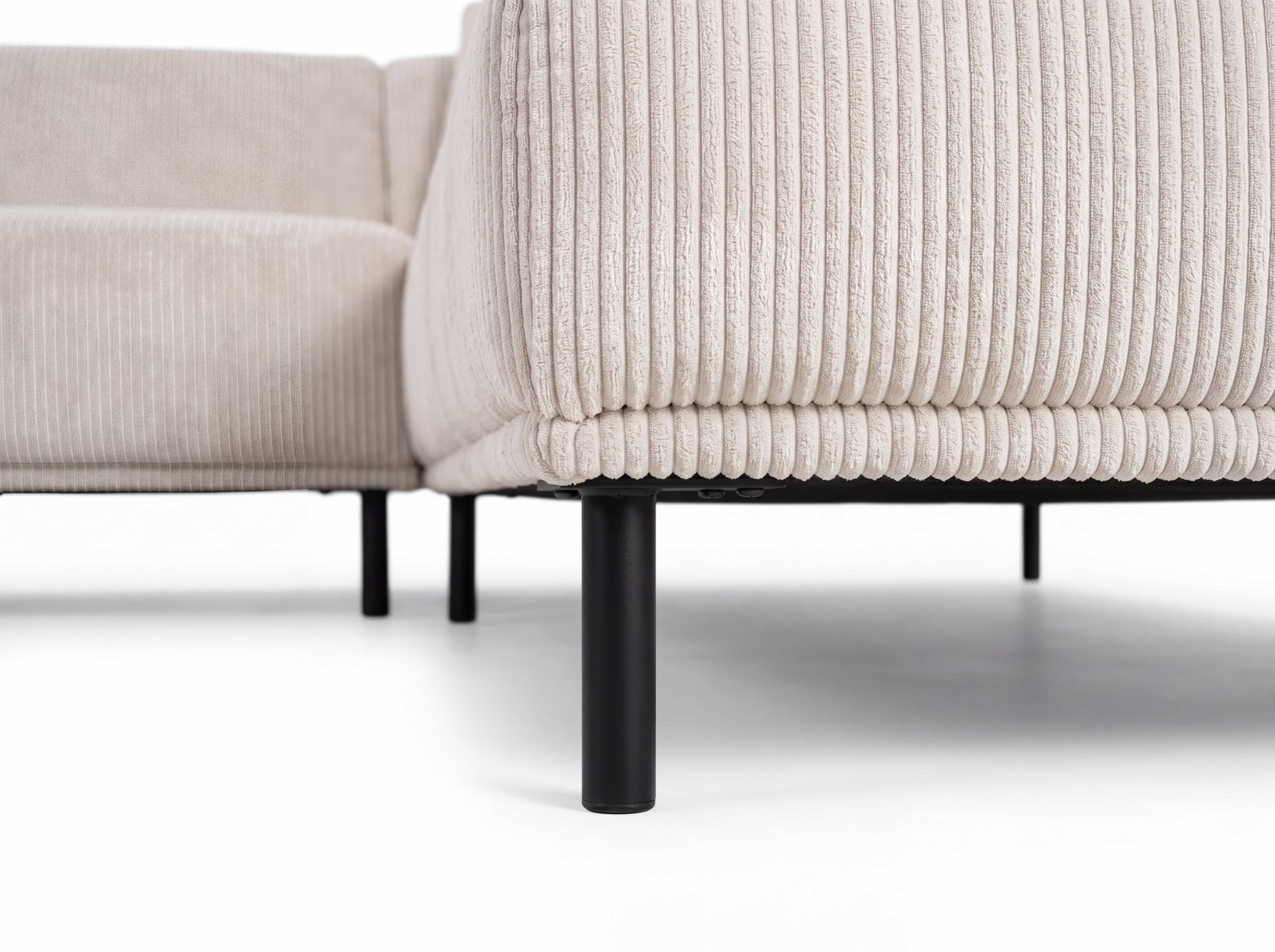 Ecksofa Modellname mit beigefarbenem Cordbezug und schwarzen, runden Metallfüßen im Detail
