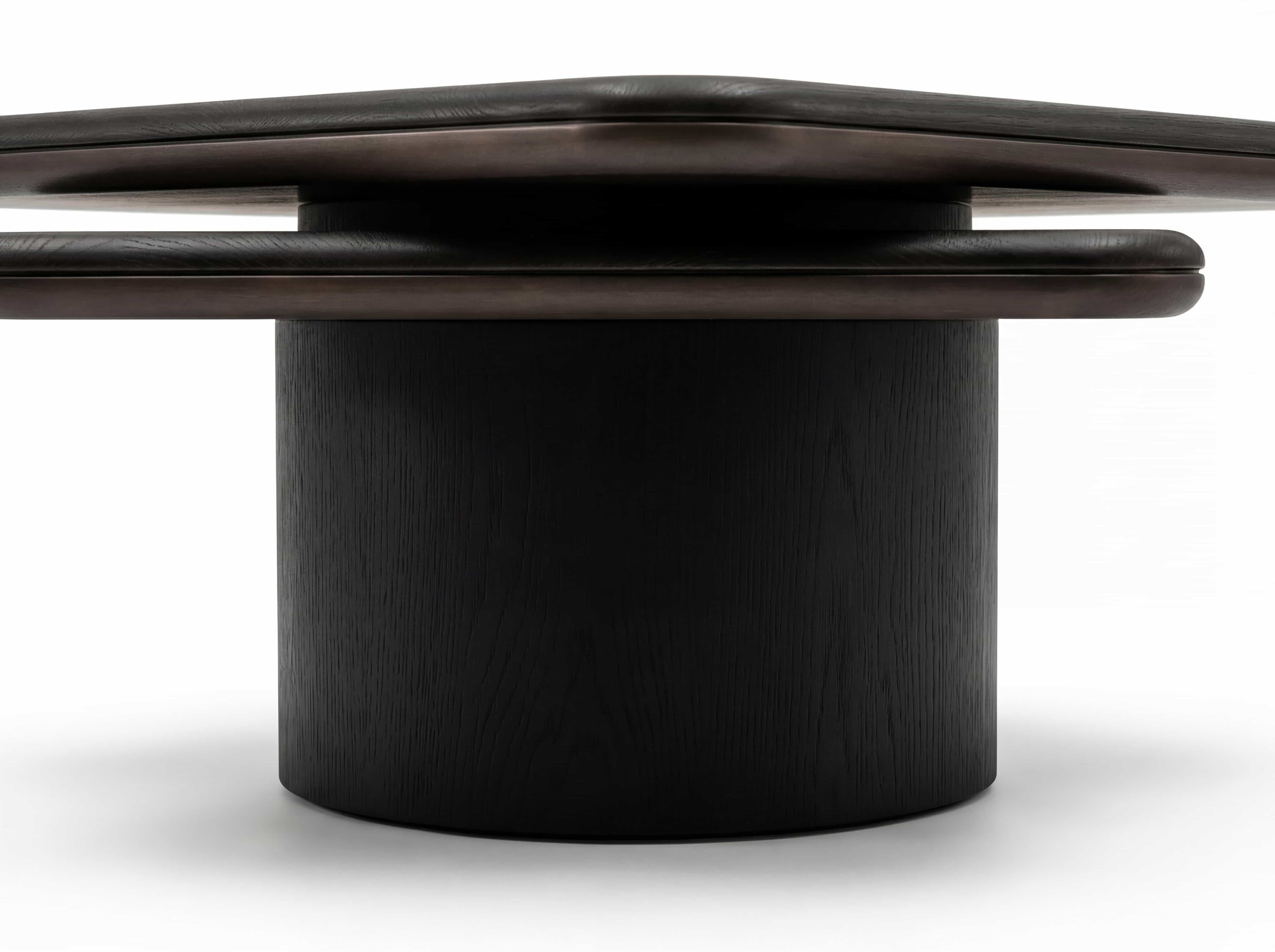 Runder Couchtisch mit zylindrischem, schwarzen Holzgestell und dunkler, massiver Tischplatte