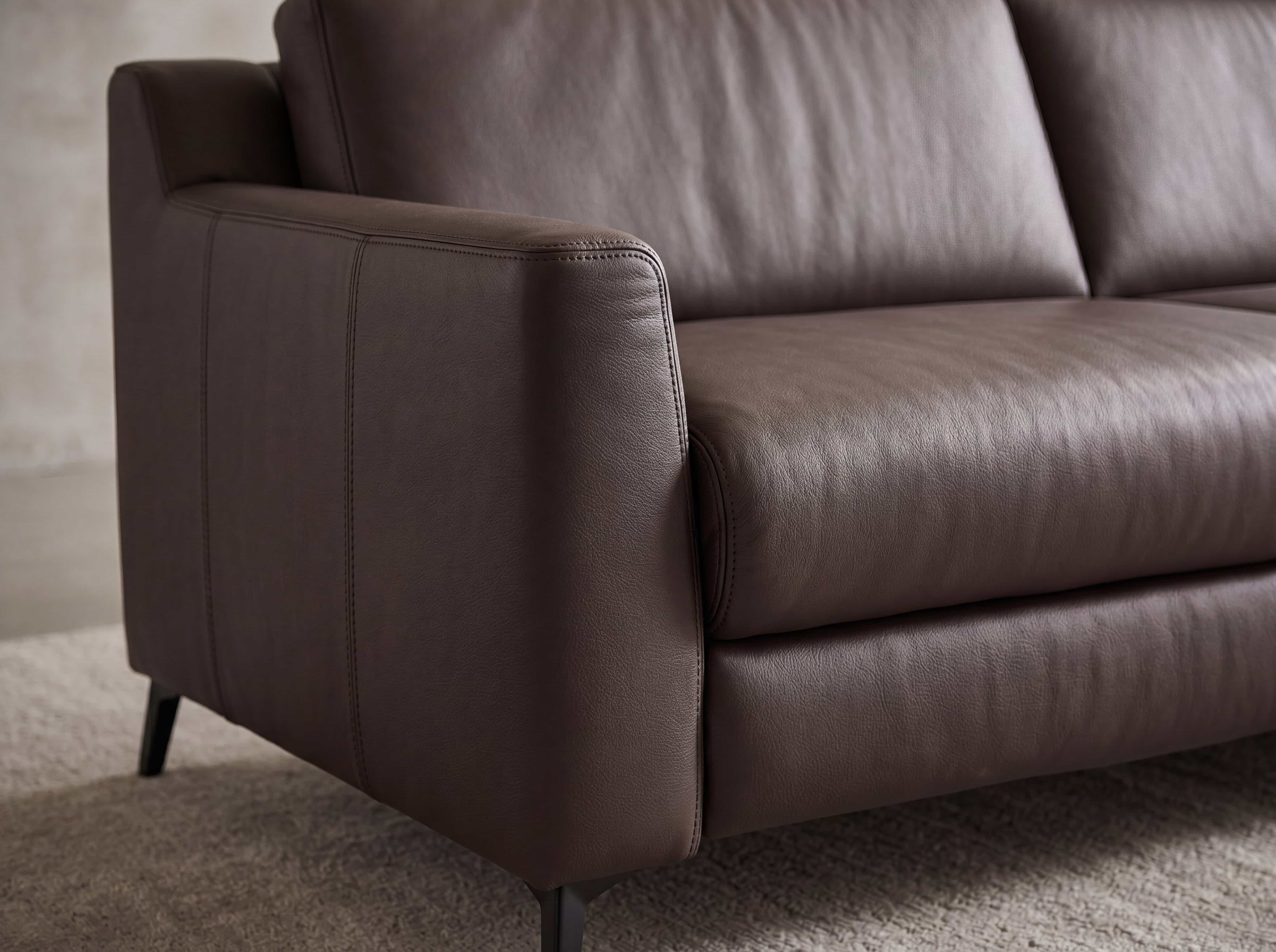 2-Sitzer Sofa mit braunem Lederbezug, gepolsterter Sitzfläche, Armlehne und schwarzen Füßen
