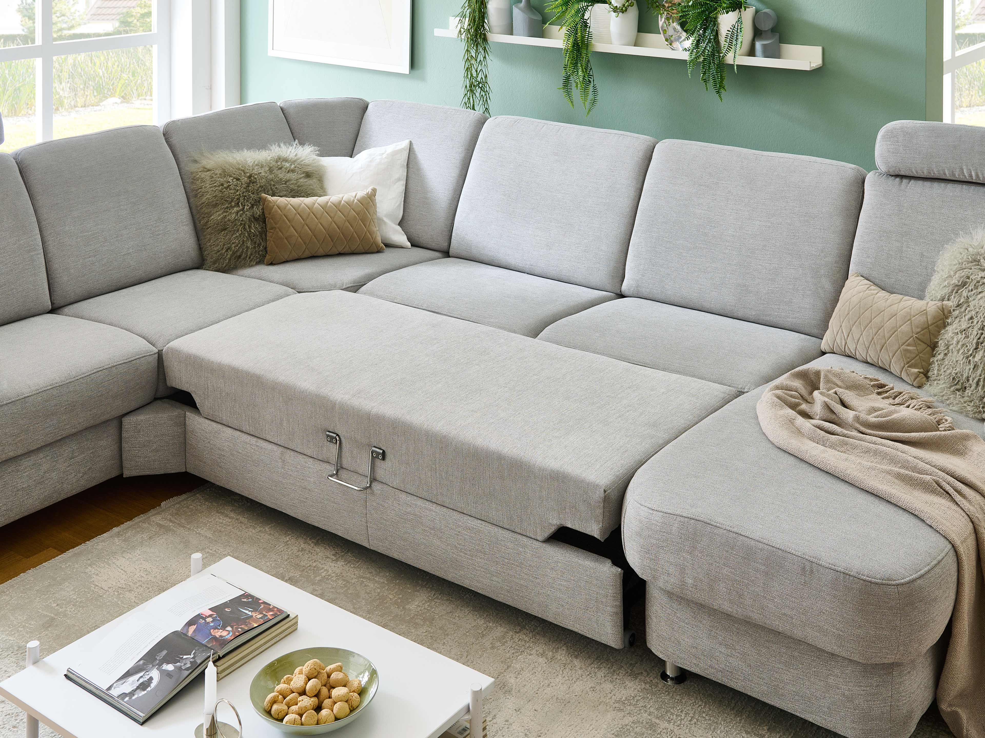 Ecksofa mit ausziehbarer Liegefläche, hellgrauer Stoffbezug, gepolsterte Rückenlehnen, L-Form