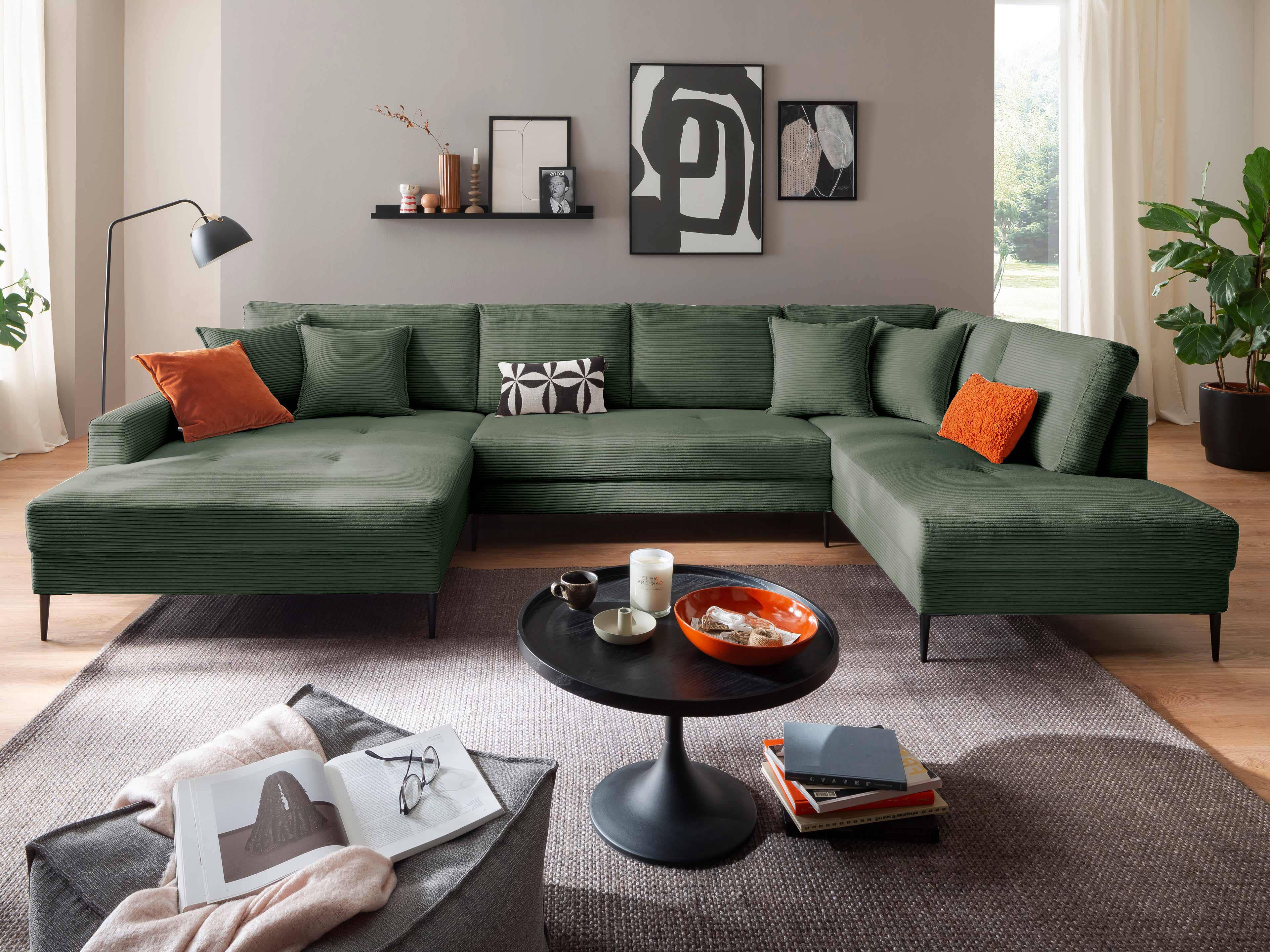 Ecksofa Arlo mit grünem Stoffbezug, gepolsterten Rückenlehnen und schwarzen Metallfüßen