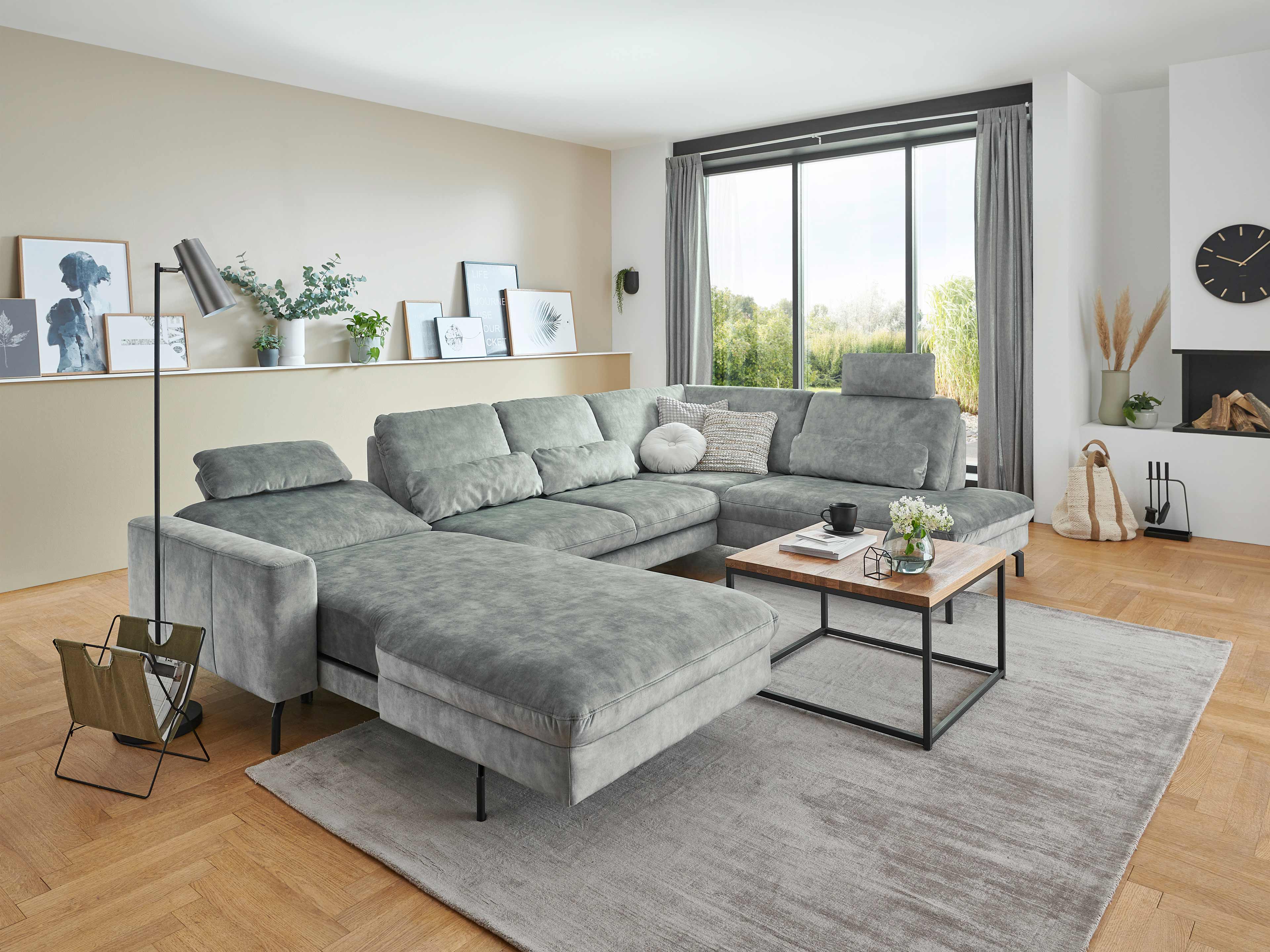 Ecksofa Kabs mit grauem Stoffbezug, L-Form, gepolsterten Rückenlehnen und schwarzen Füßen