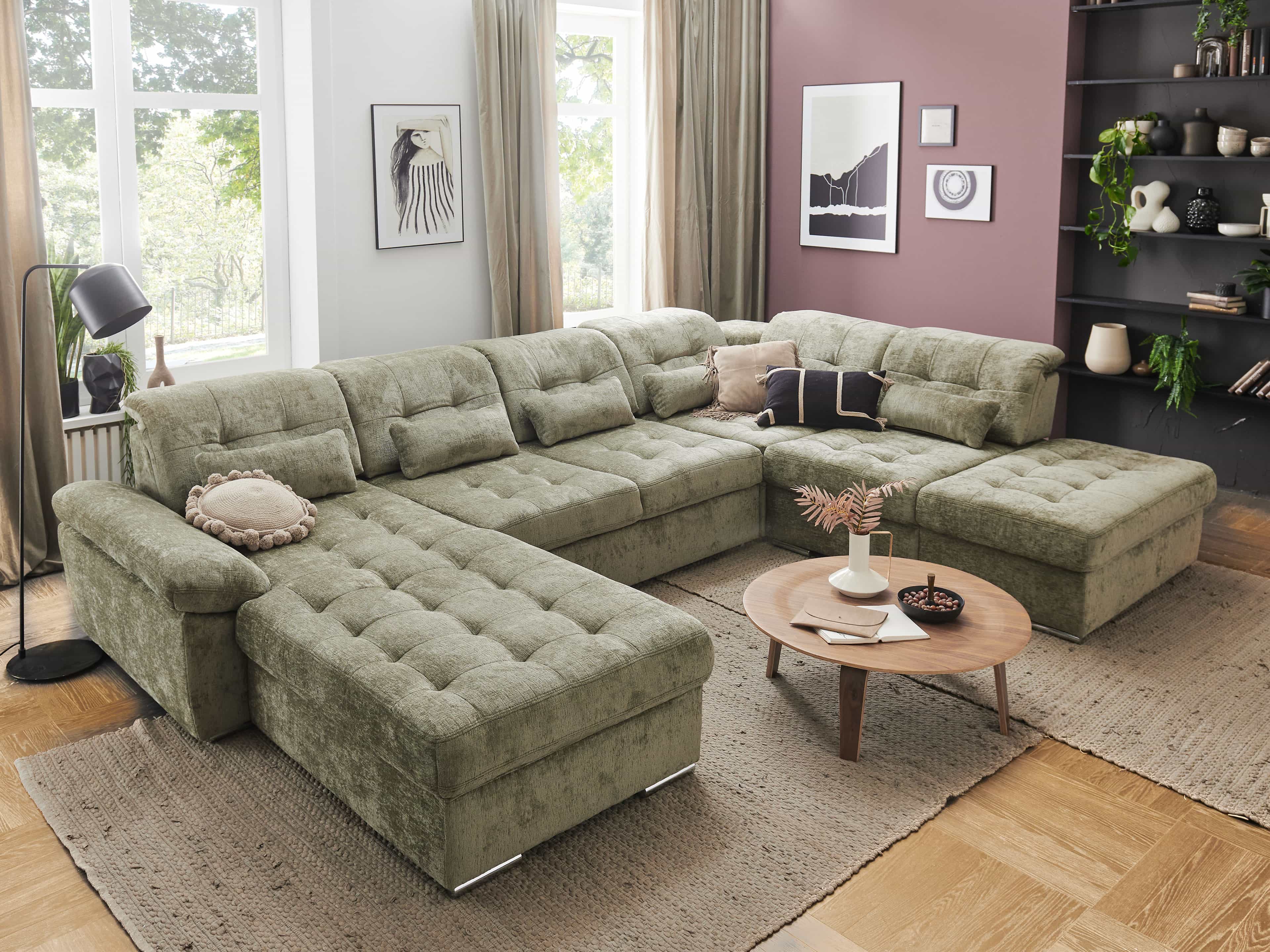 Ecksofa mit grüner Stoffpolsterung, breiten Armlehnen, Récamiere, gepolsterten Rückenkissen