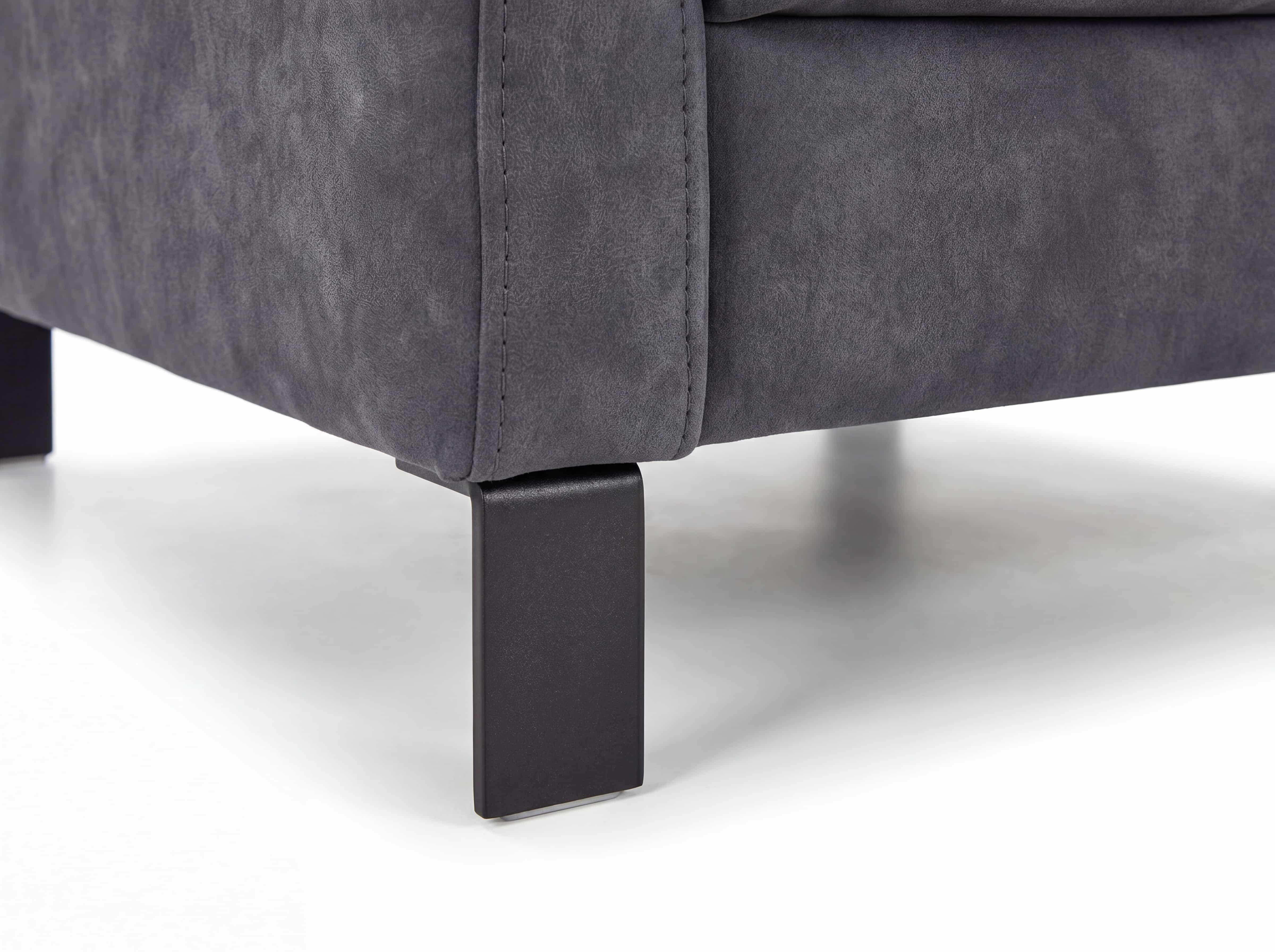 Ecksofa in grauem Stoffbezug mit eckigen schwarzen Metallfüßen, sichtbare Naht an der Sofaecke