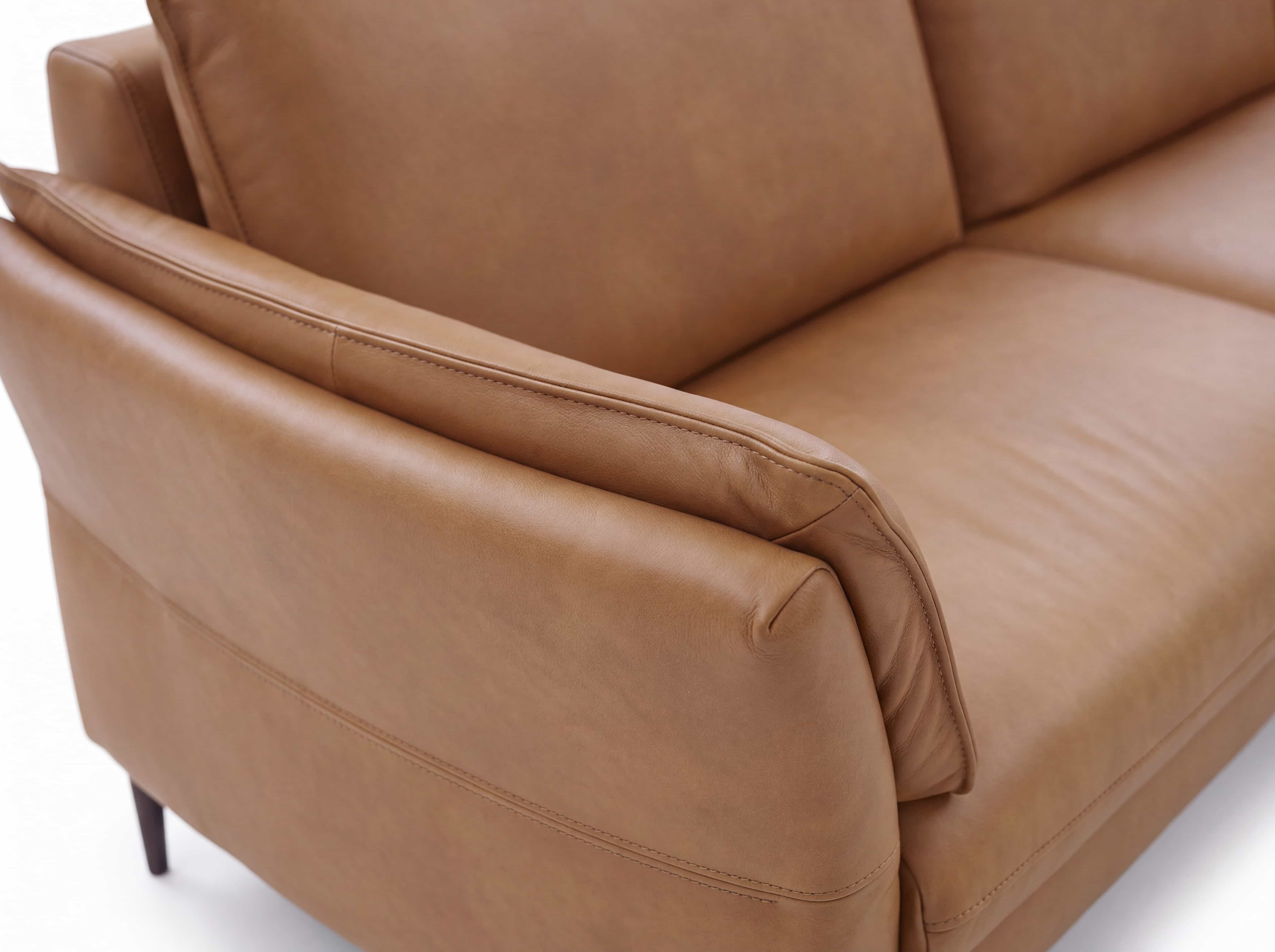 3-Sitzer Sofa mit cognacfarbenem Lederbezug, gepolsterter Sitzfläche und Armlehne, Detailansicht