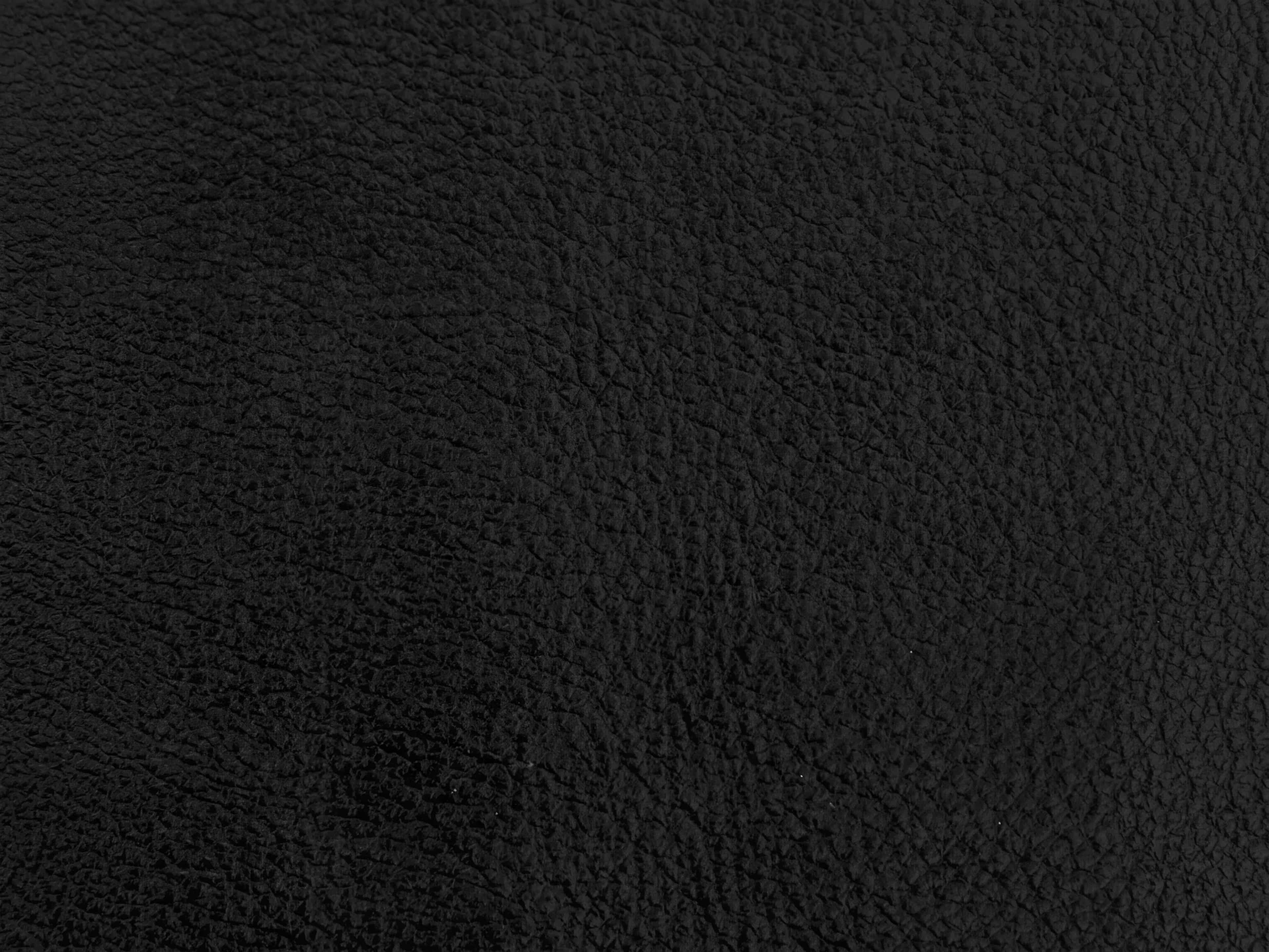 Schwarze Lederoberfläche mit natürlicher Narbung, gleichmäßig strukturiert und matt glänzend