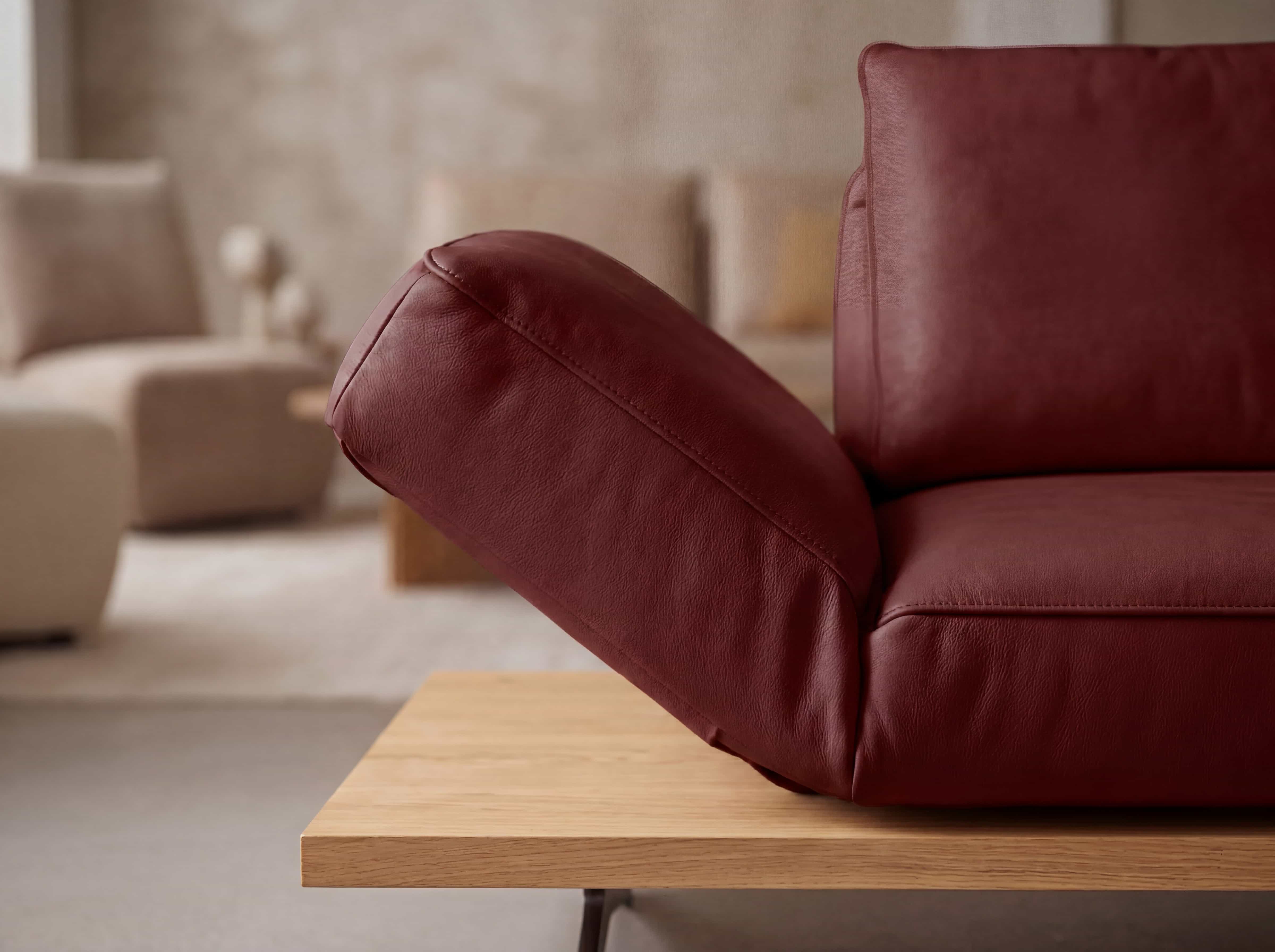 Ecksofa mit braunrotem Lederbezug und verstellbarer Kopfstütze, Sitzfläche und Armlehne sichtbar