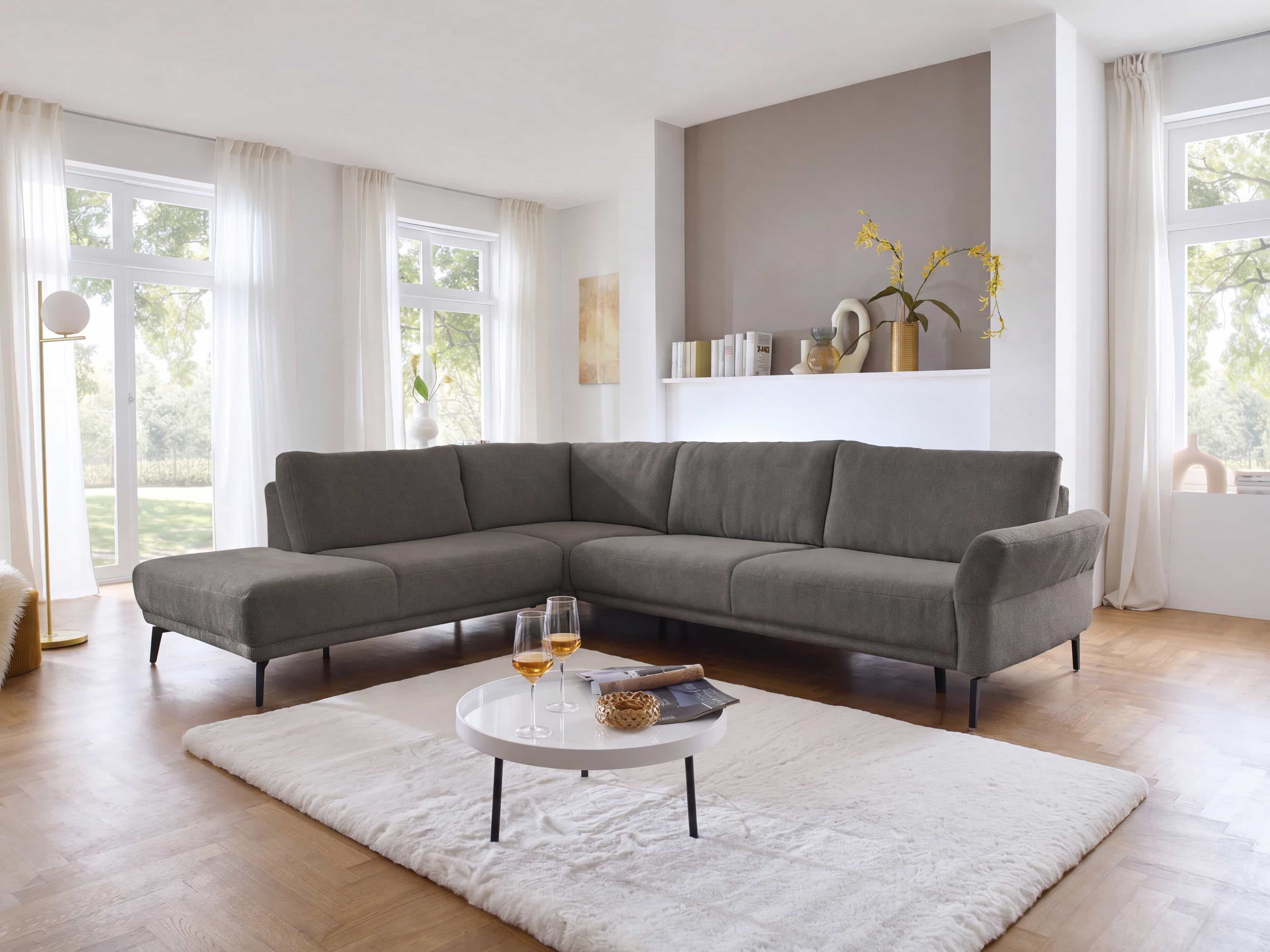 Ecksofa Kabs Polsterwelt mit grauem Stoffbezug, L-Form, Armlehnen und schmalen schwarzen Füßen