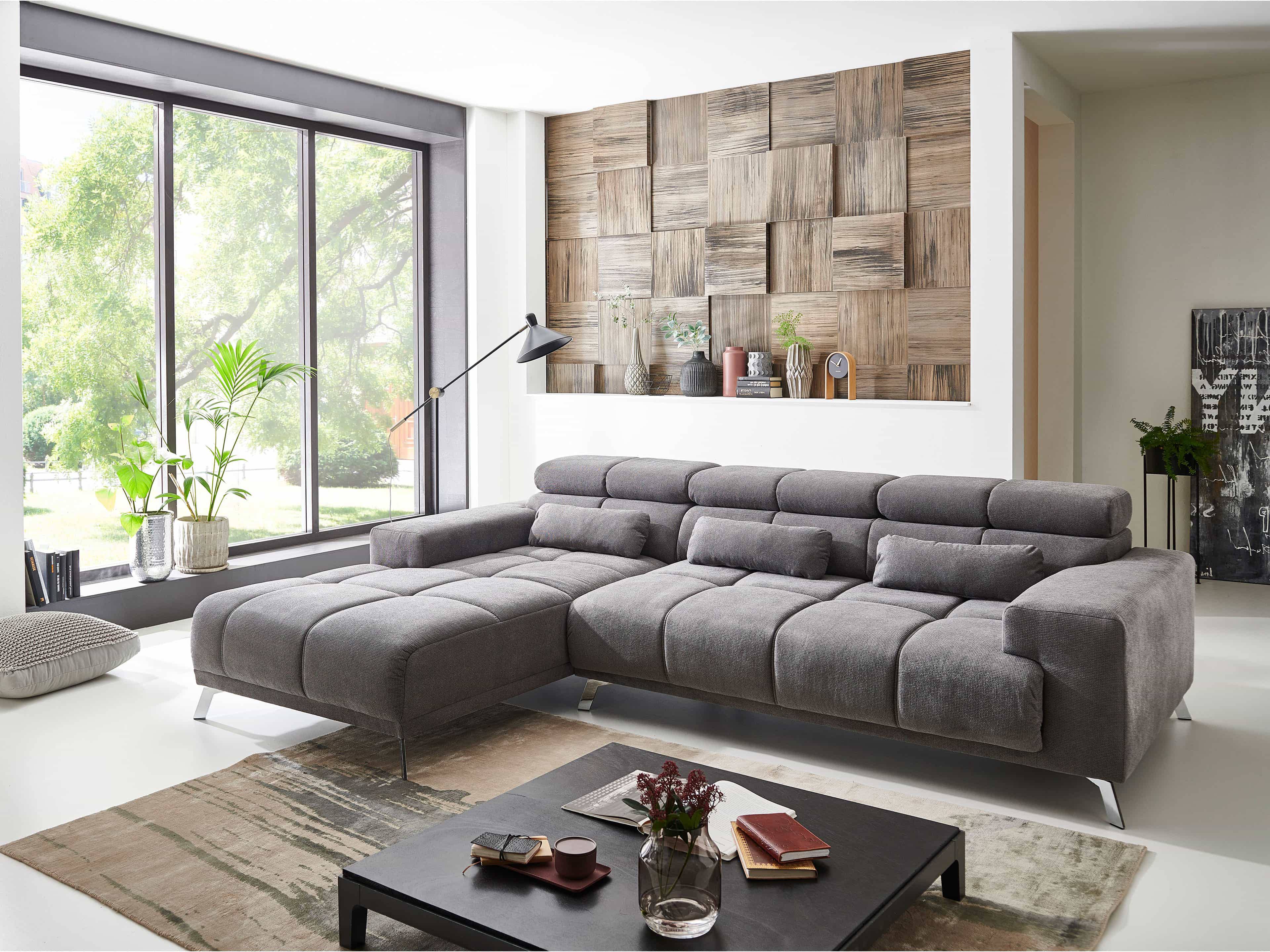 Ecksofa Kabs Polsterwelt mit grauem Stoffbezug, breiten Armlehnen und gepolsterten Rückenlehnen