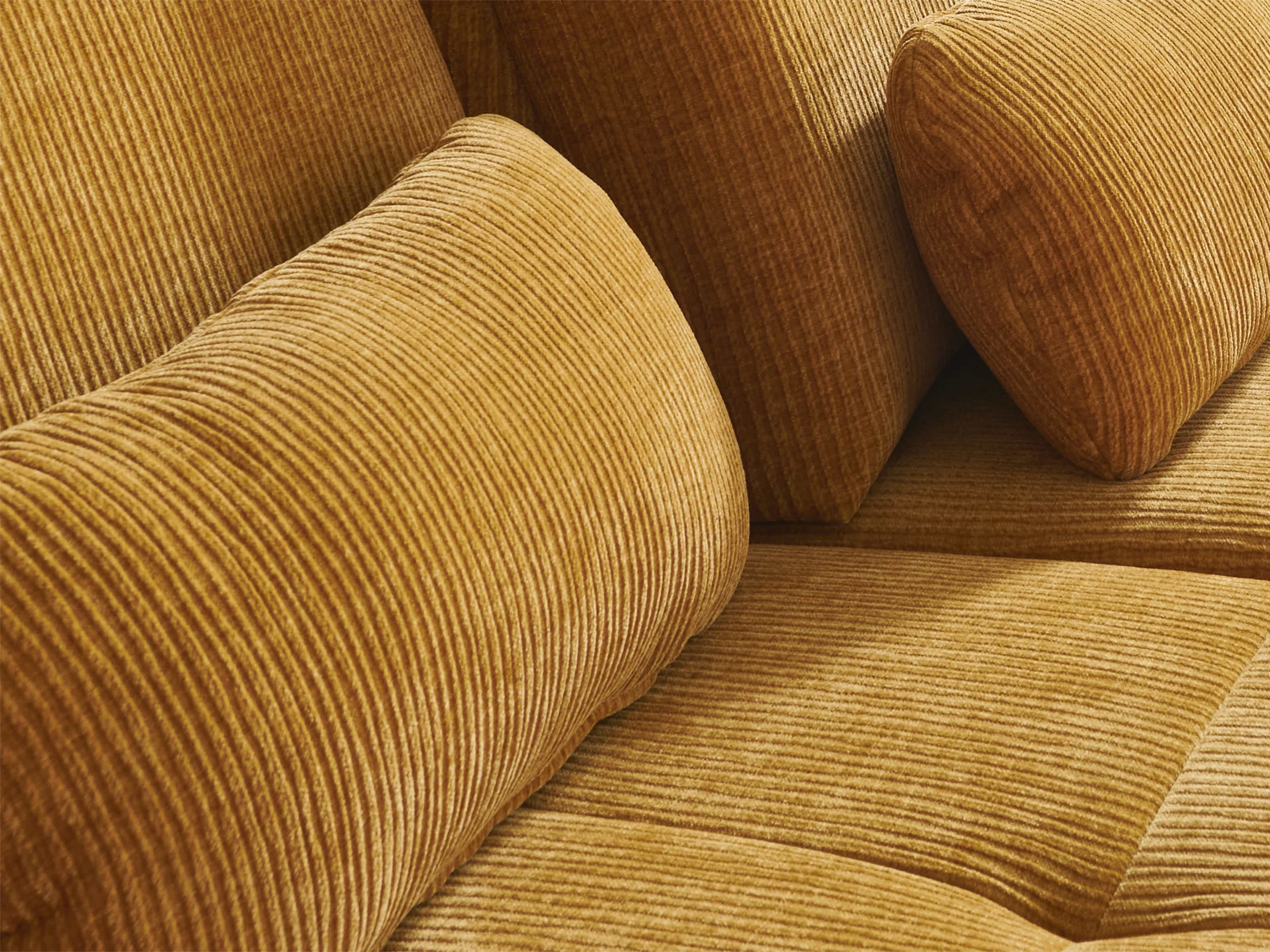 Sofa mit weichem, goldgelbem Cordbezug und markanter Rippenstruktur, gepolsterte Rückenlehne