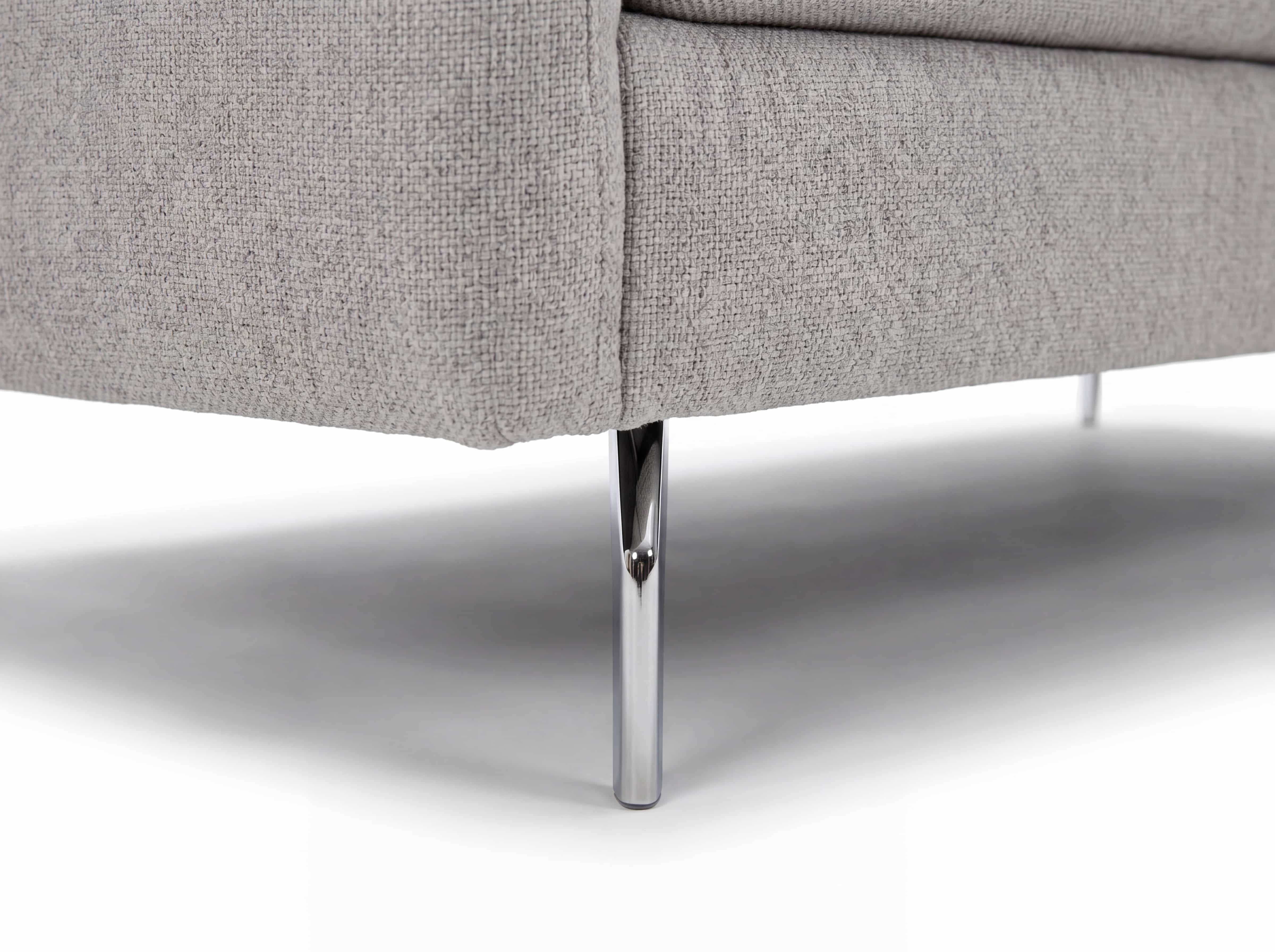 Sofa mit hellgrauem Stoffbezug und rundem Metallfuß in Chromoptik, Detailaufnahme der Ecke