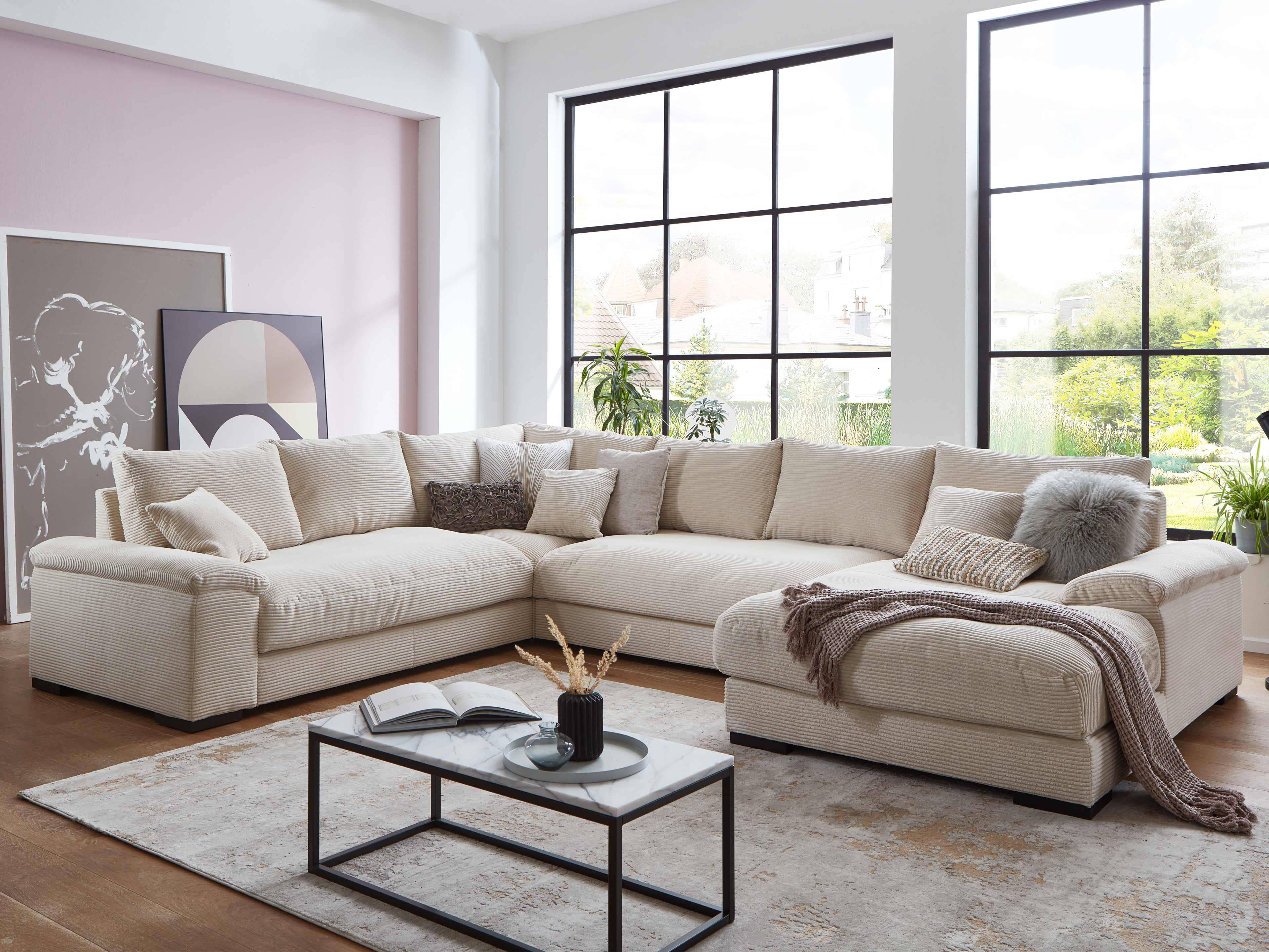 Ecksofa Kabs Polsterwelt mit beigem Stoffbezug, breiten Armlehnen, gepolsterten Sitzflächen und Kissen