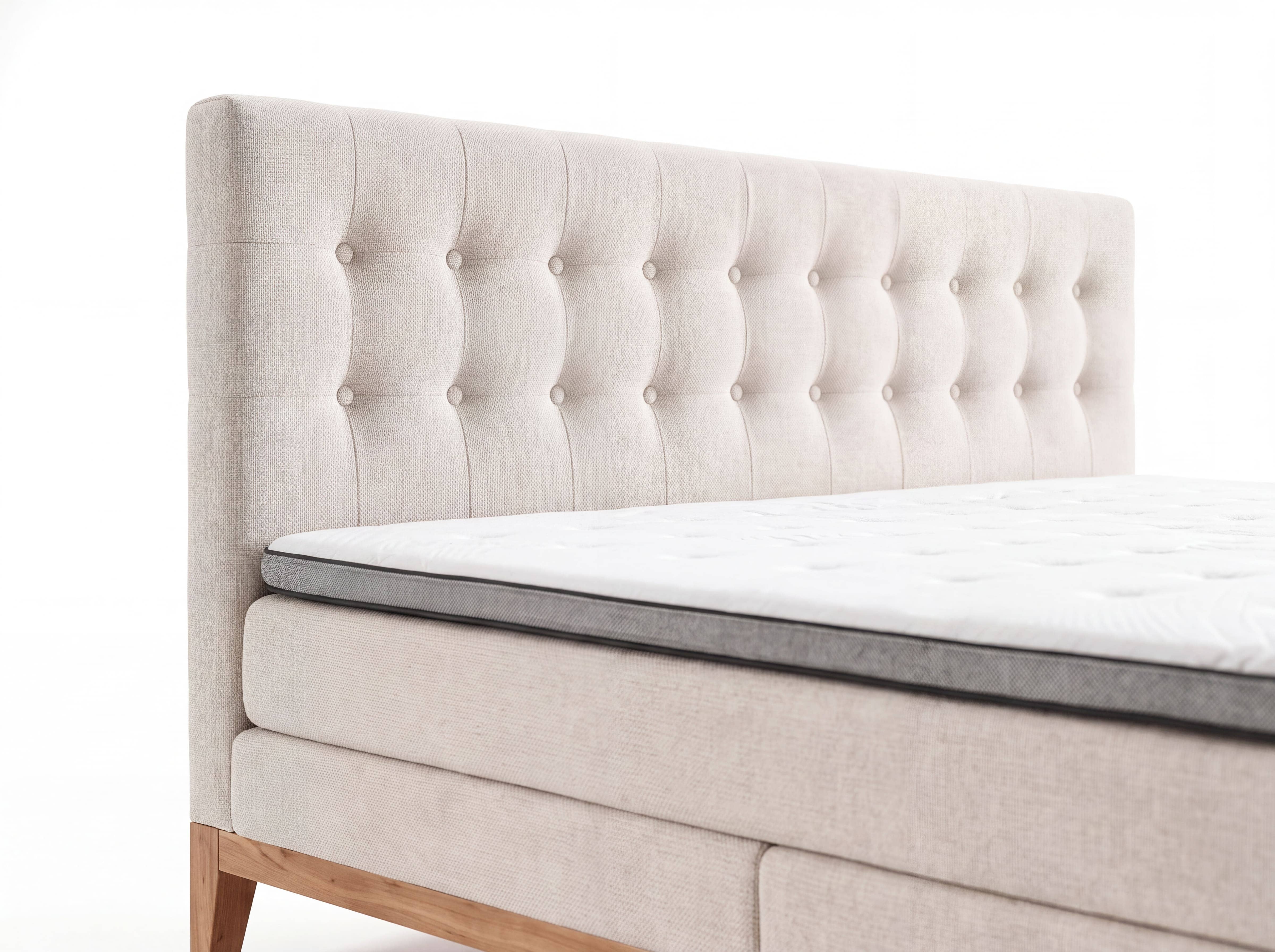 Boxspringbett mit gepolstertem, beigefarbenem Stoffbezug und gestepptem Kopfteil, Holzfüße