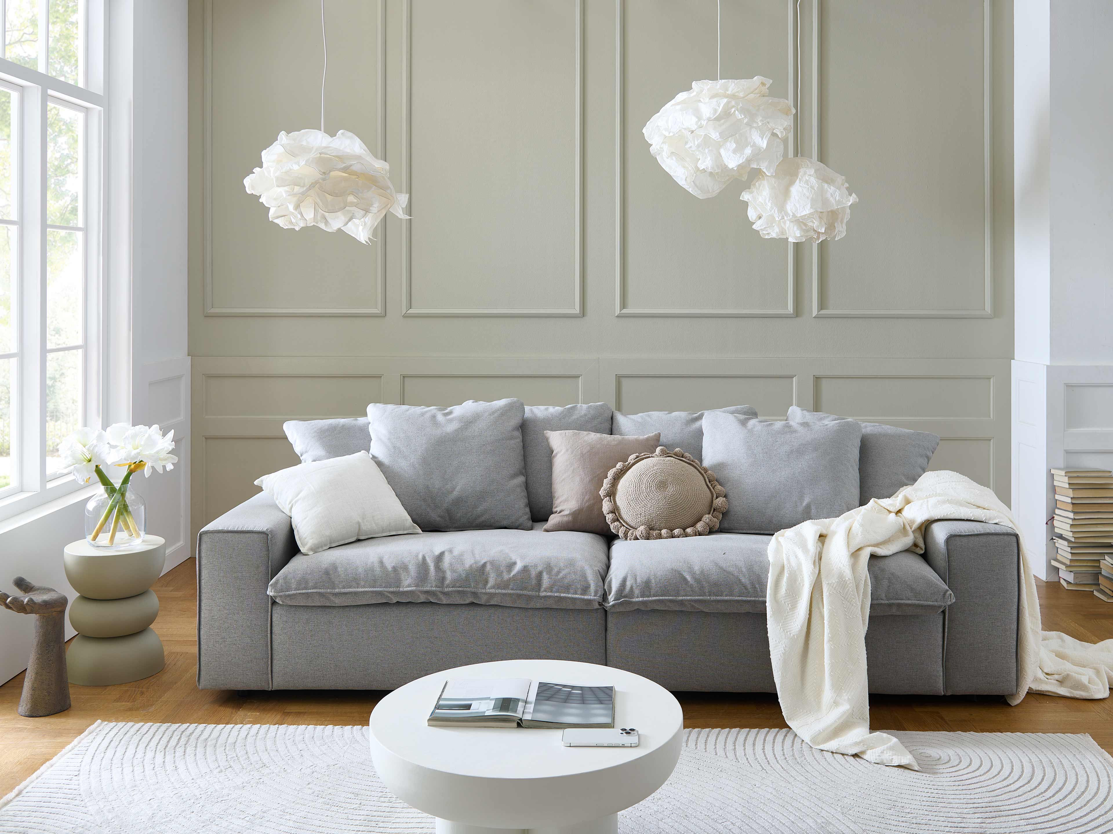 3-Sitzer-Sofa Kabs Polsterwelt mit grauem Stoffbezug, breiten Armlehnen und mehreren Kissen