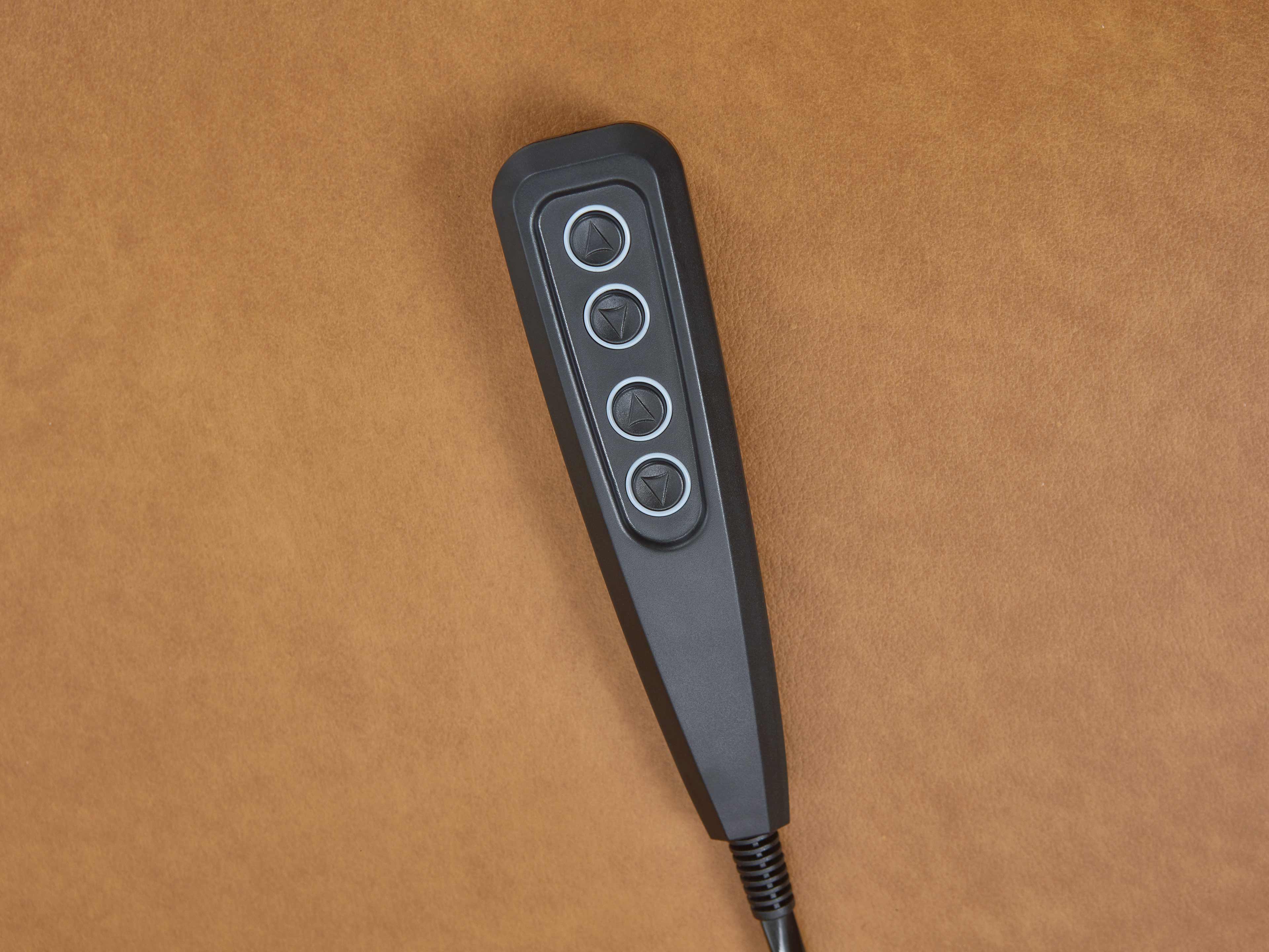 Schwarze Fernbedienung mit vier Tasten auf braunem Leder, geeignet für elektrisch verstellbares Sofa