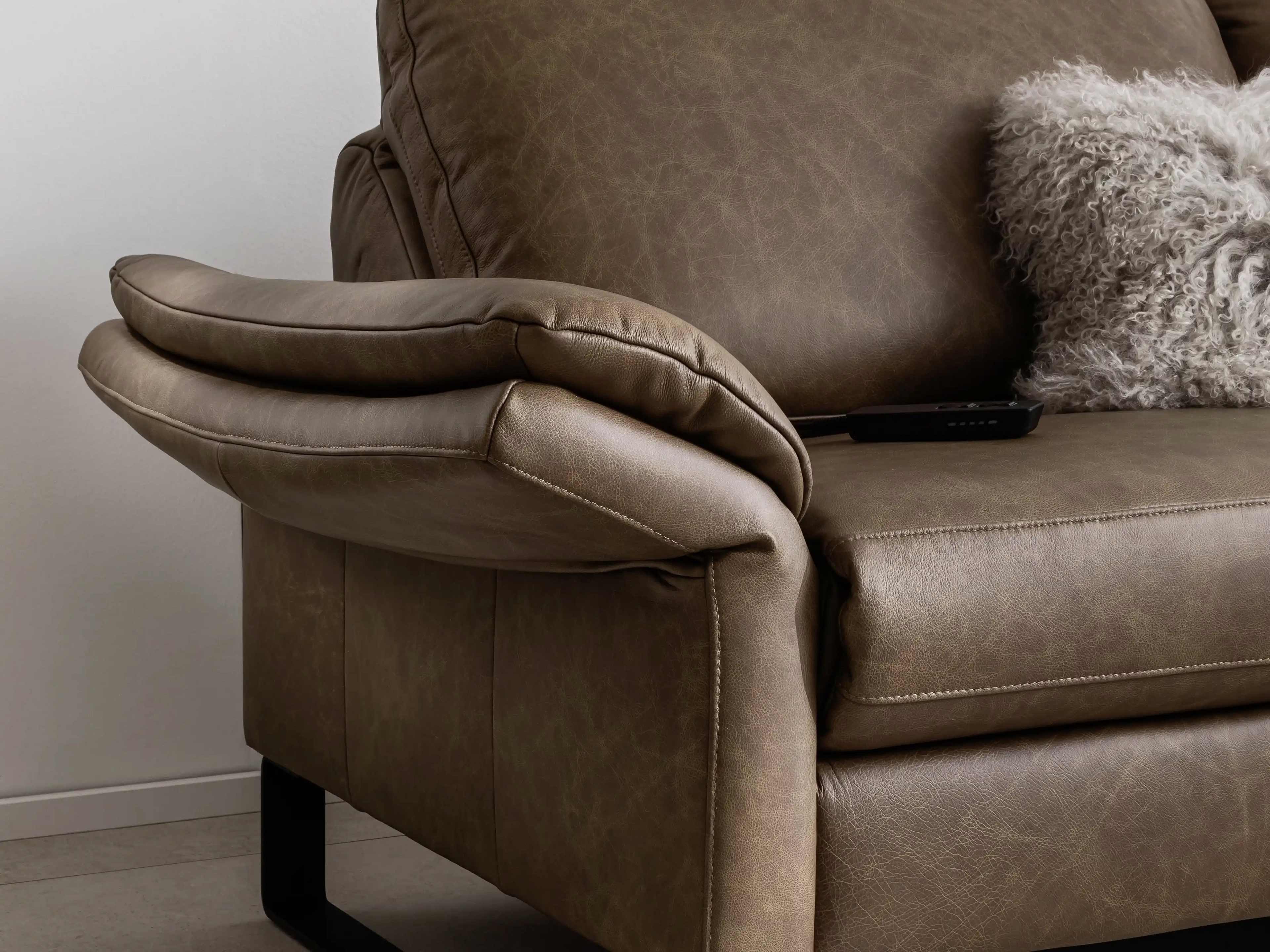 Ecksofa Relax braun mit Lederbezug, gepolsterter Armlehne und Metallfuß, Nahaufnahme der Seite