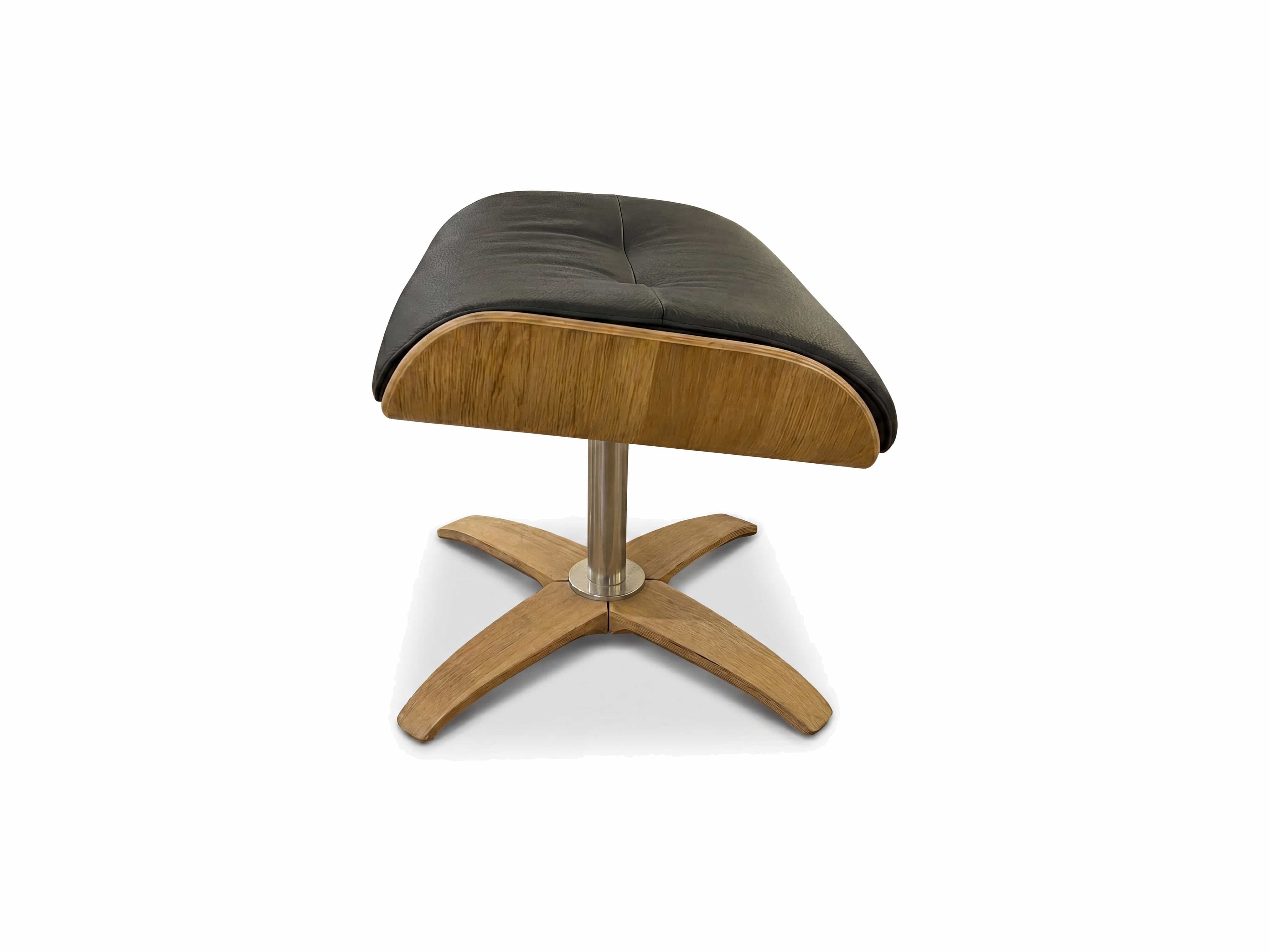 Hocker mit schwarzem Lederbezug, geschwungener Holzschale und vierbeinigem Holzfuß kreuzförmig
