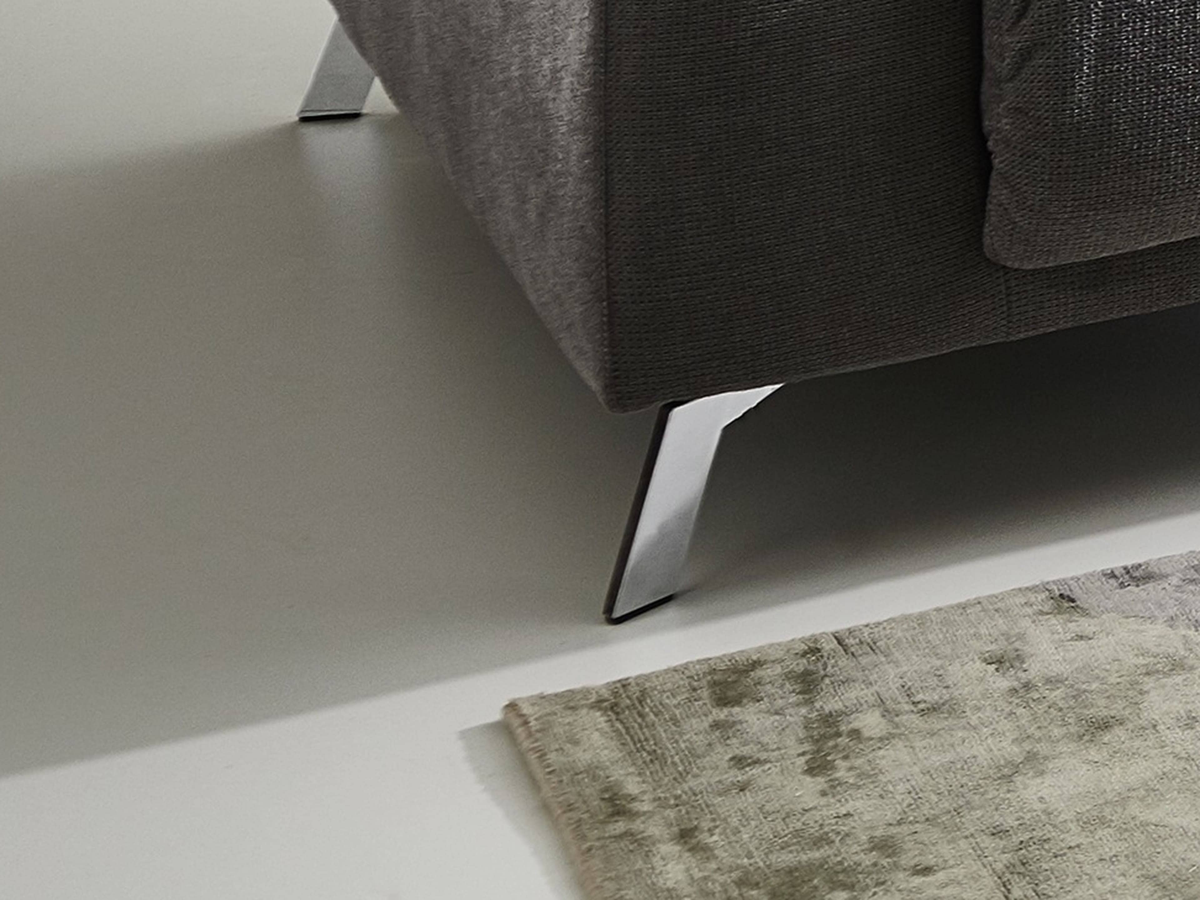 Ecksofa mit dunkelgrauem Stoffbezug und schrägen Metallfüßen, sichtbare gepolsterte Seitenpartie